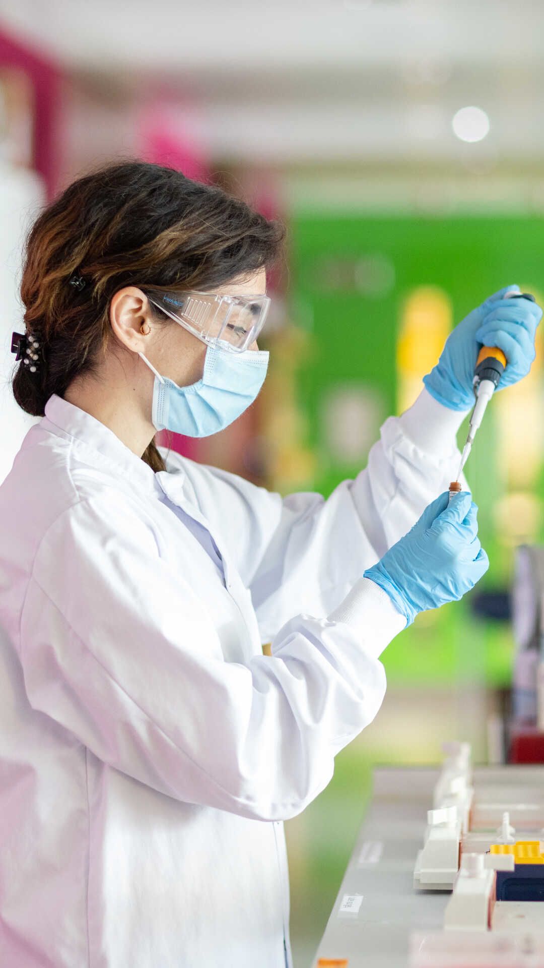 A researcher in the Energy Futures Lab with lab coat, goggles and dropper