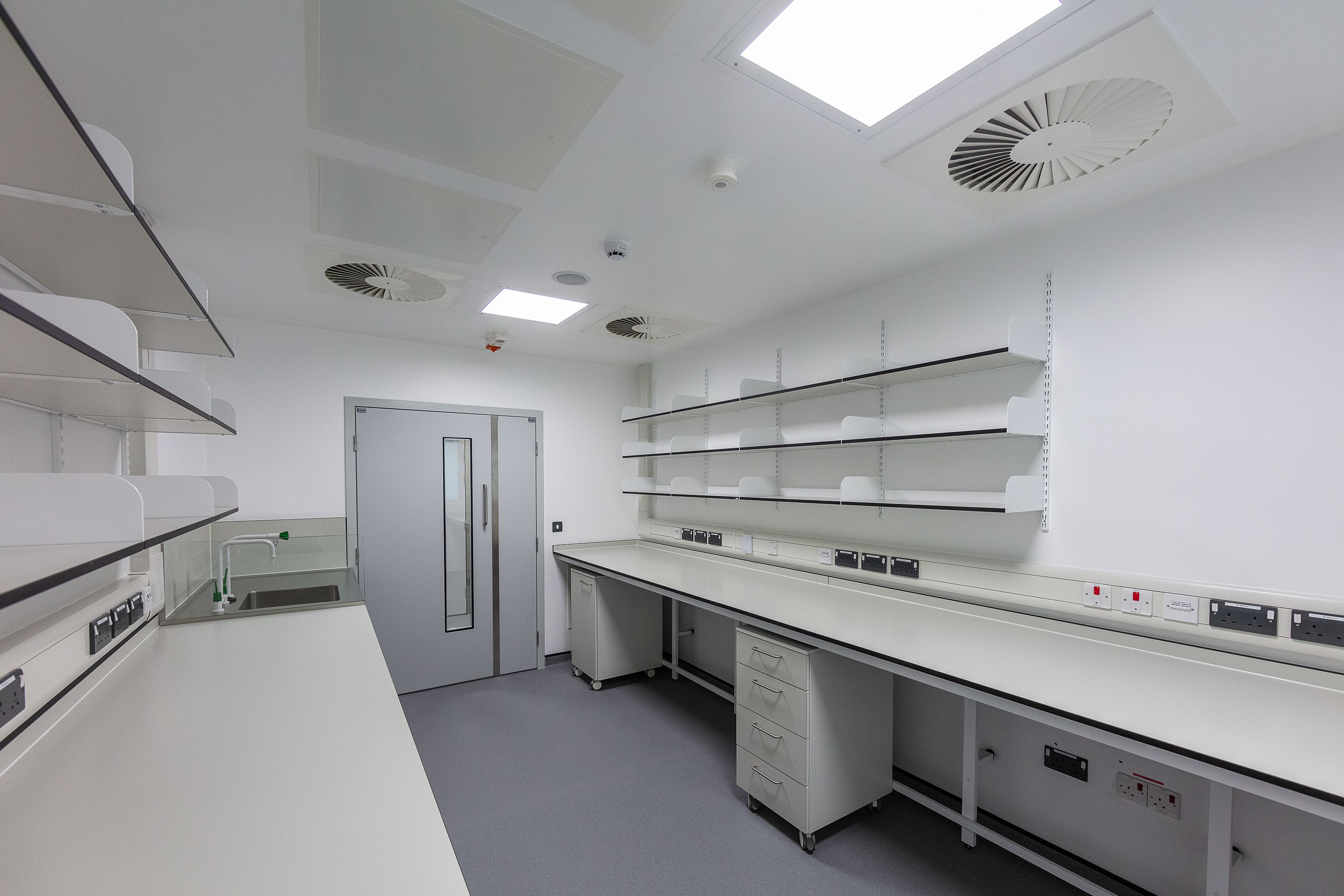 A workbench area, with under counter storage, shelves above and powerbanks 