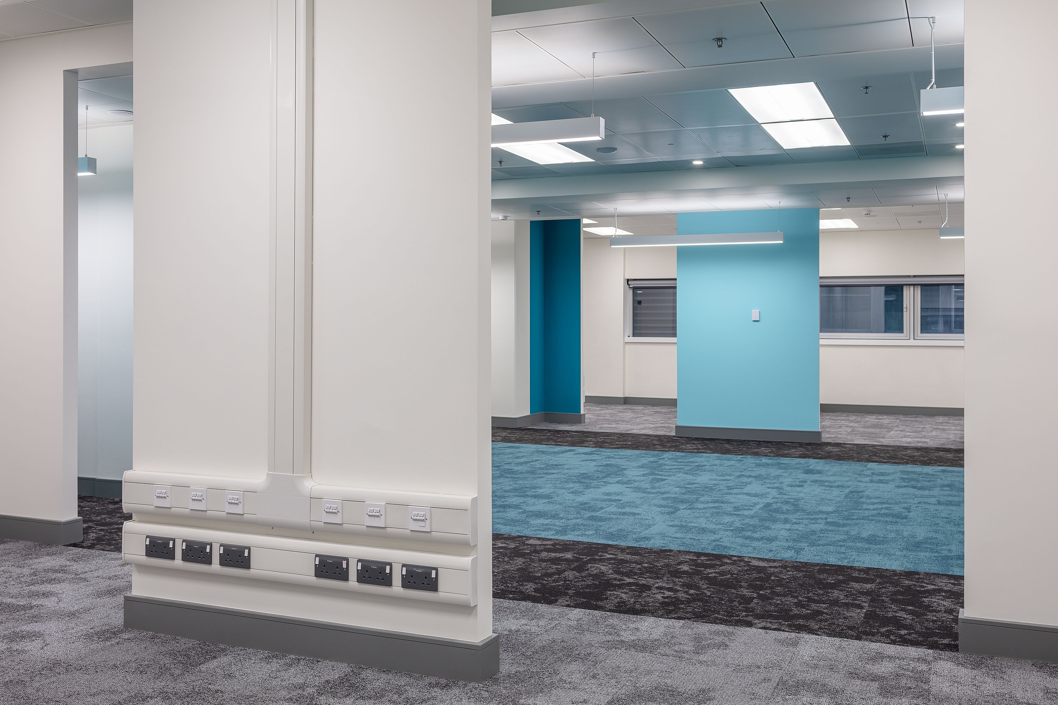 Power banks on a communcal area wall. The colours of the decor are blue and teal and white
