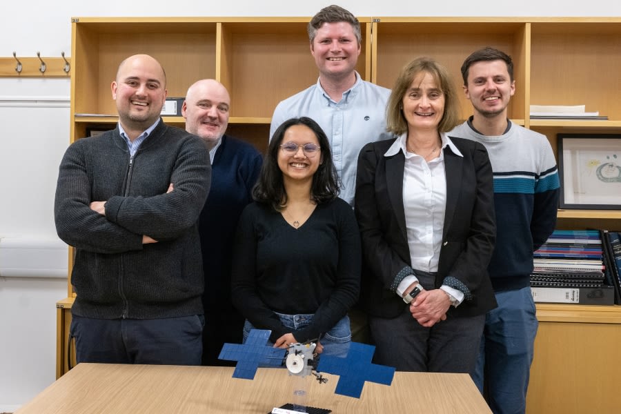 A group of people standing in front of a Lego model of a spacecraft