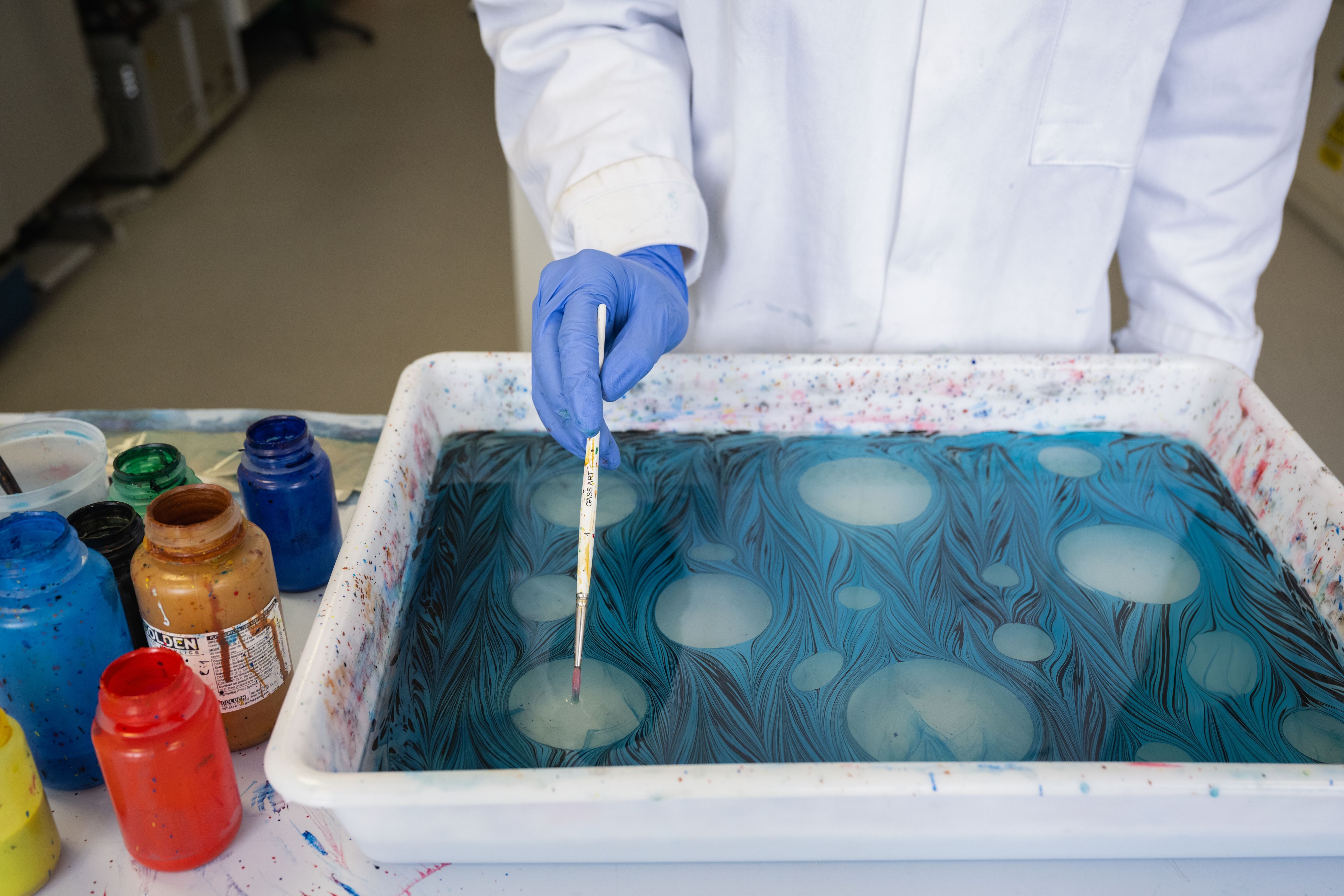 Close up view of Liva's marbling container showing different patterns in the liquid.