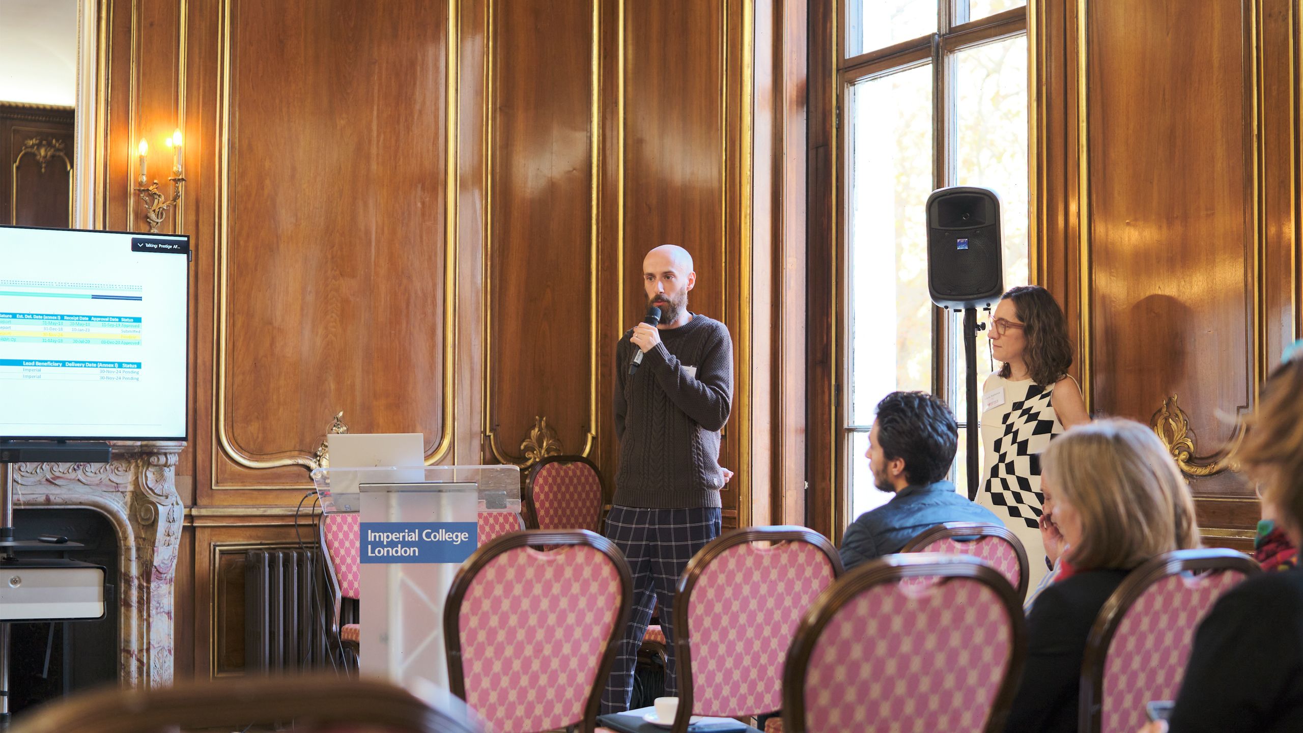 man speaking with microphone in front of audience