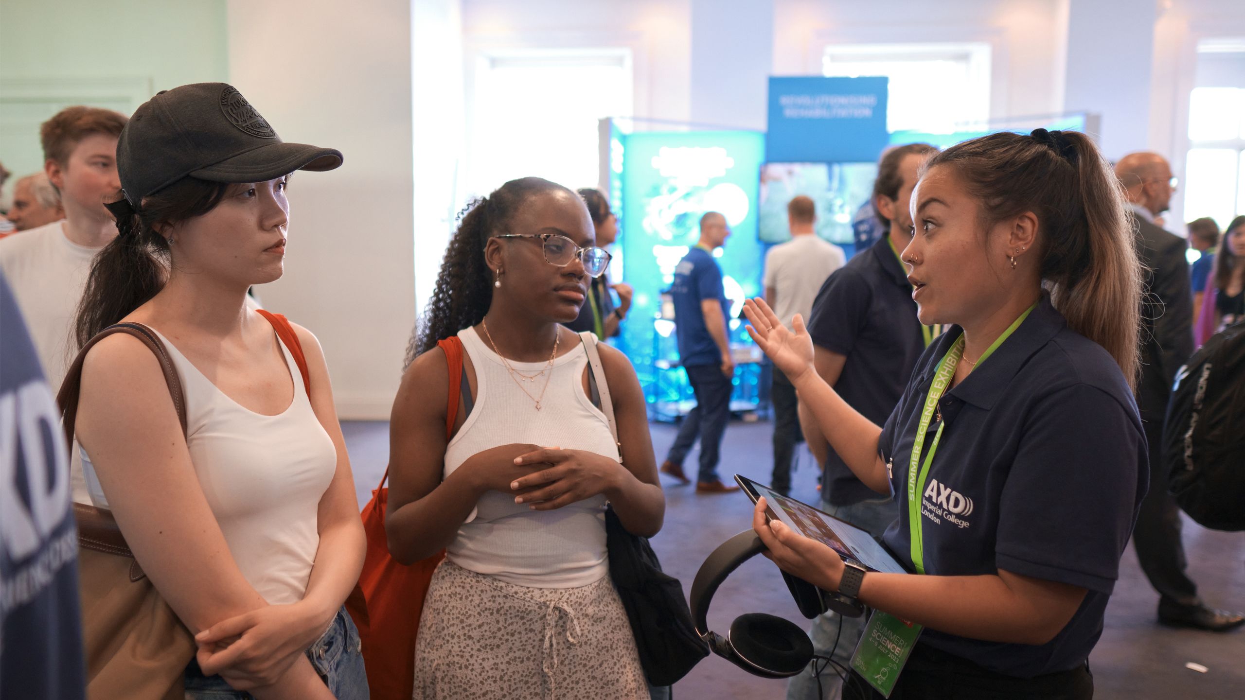 one women speaking to two other women at a science fair