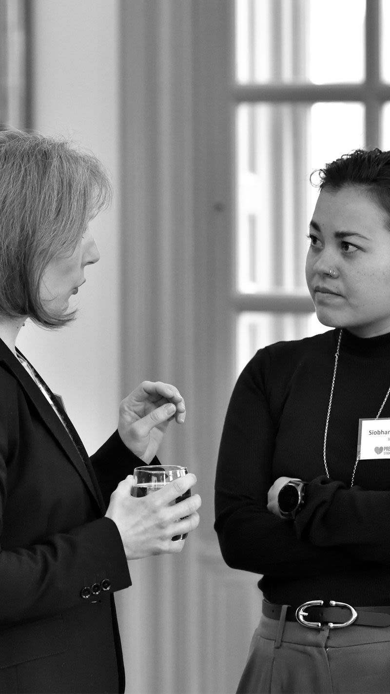 two women in business attire having a conversation