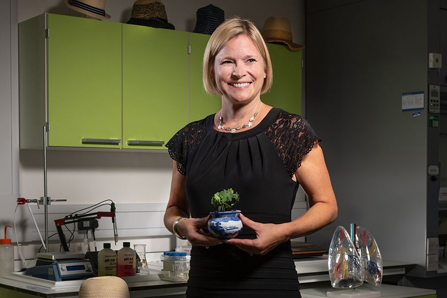 Cecilia in lab holds seedling