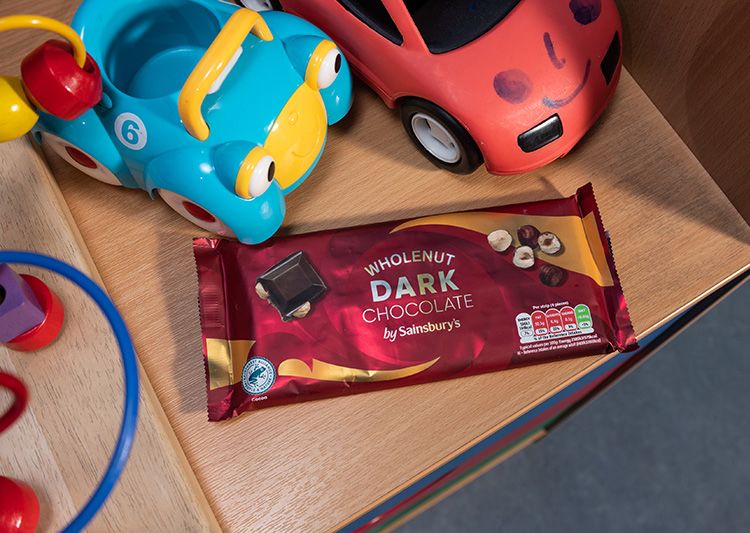 Darl chocolate sitting on table with toy cars