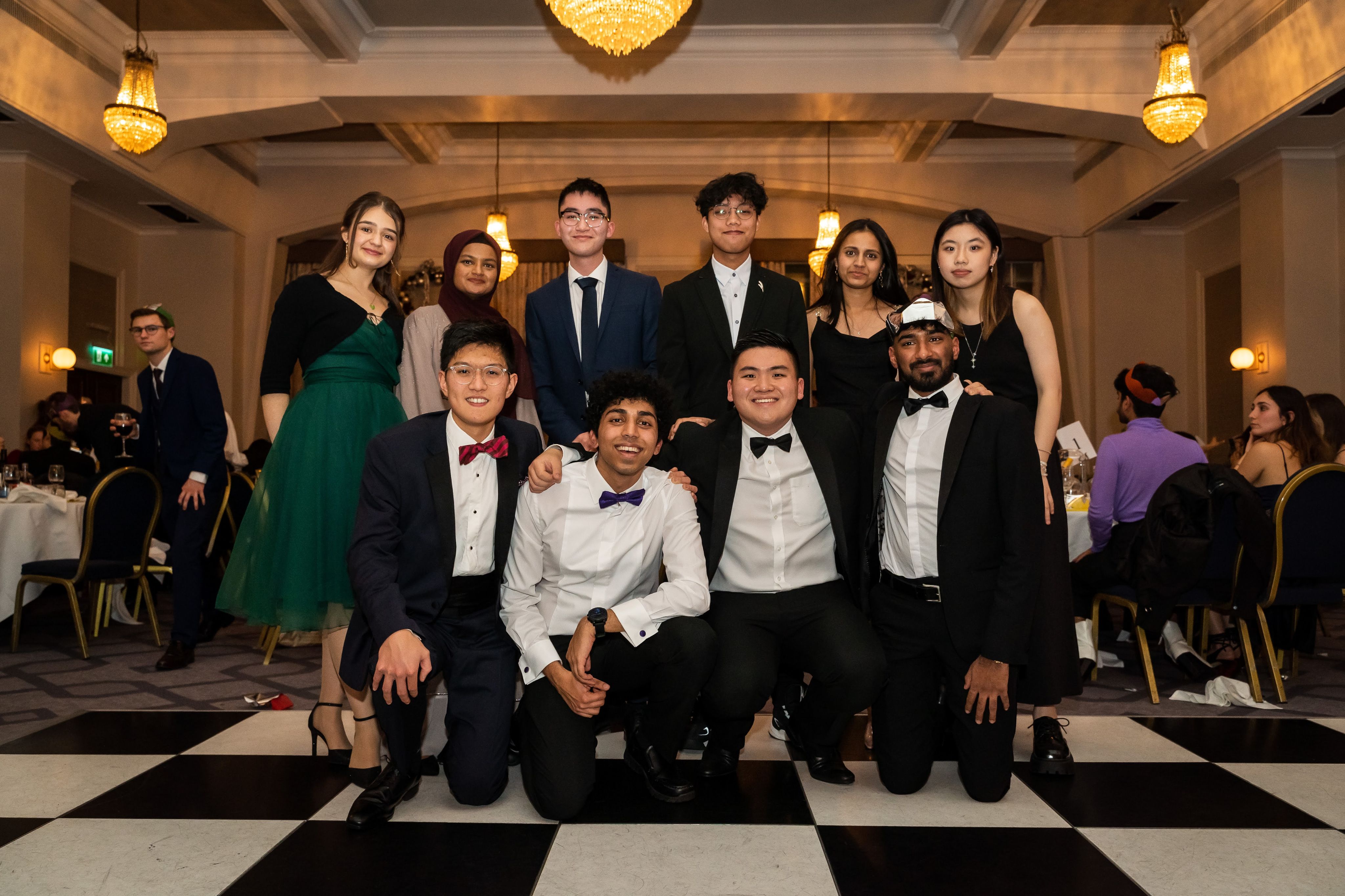 Cristiana with friends who are wearing formal dress. Christiana is wearing a green dress