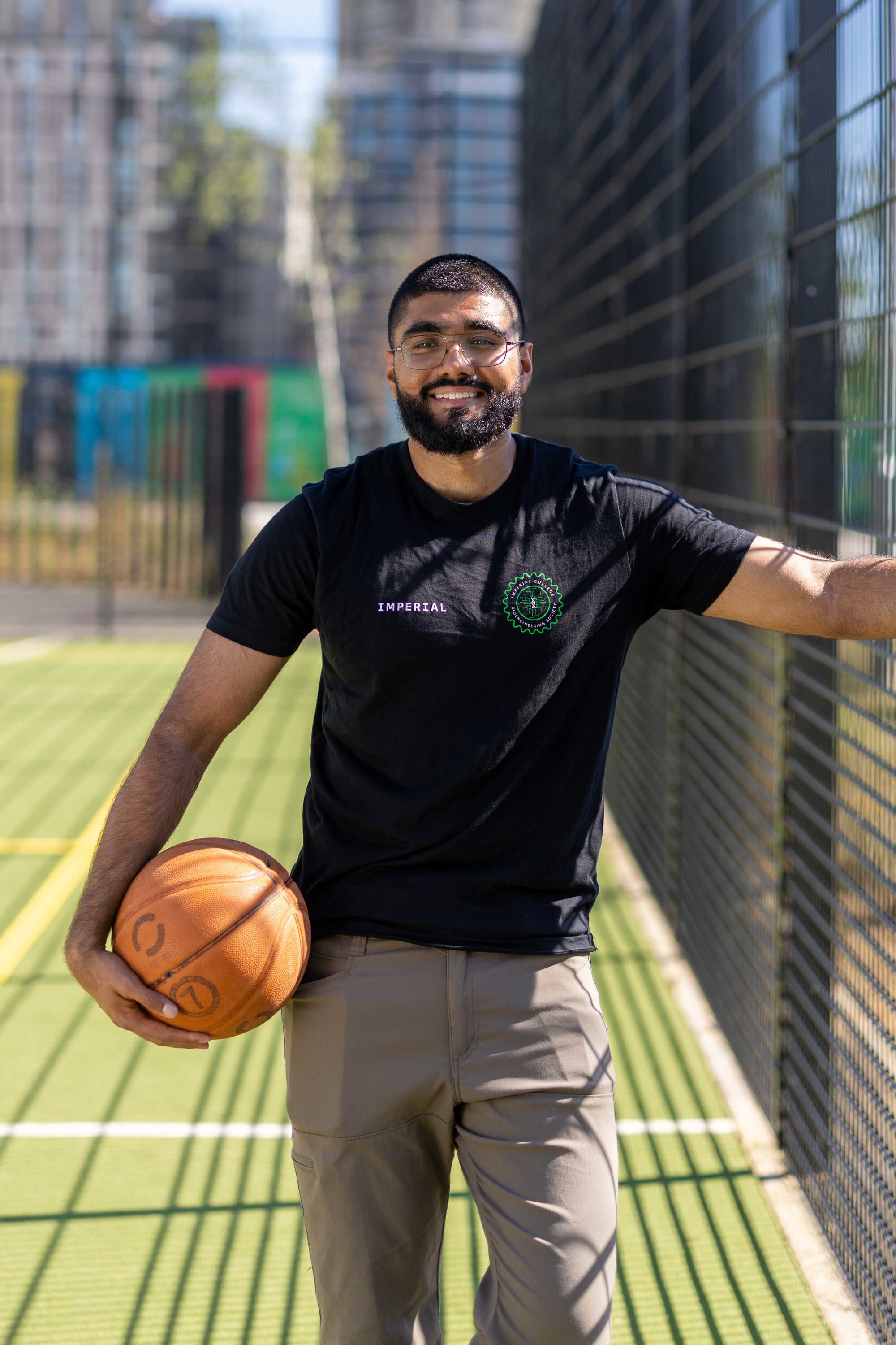Haaris holding a basketball on an outdoor sports court