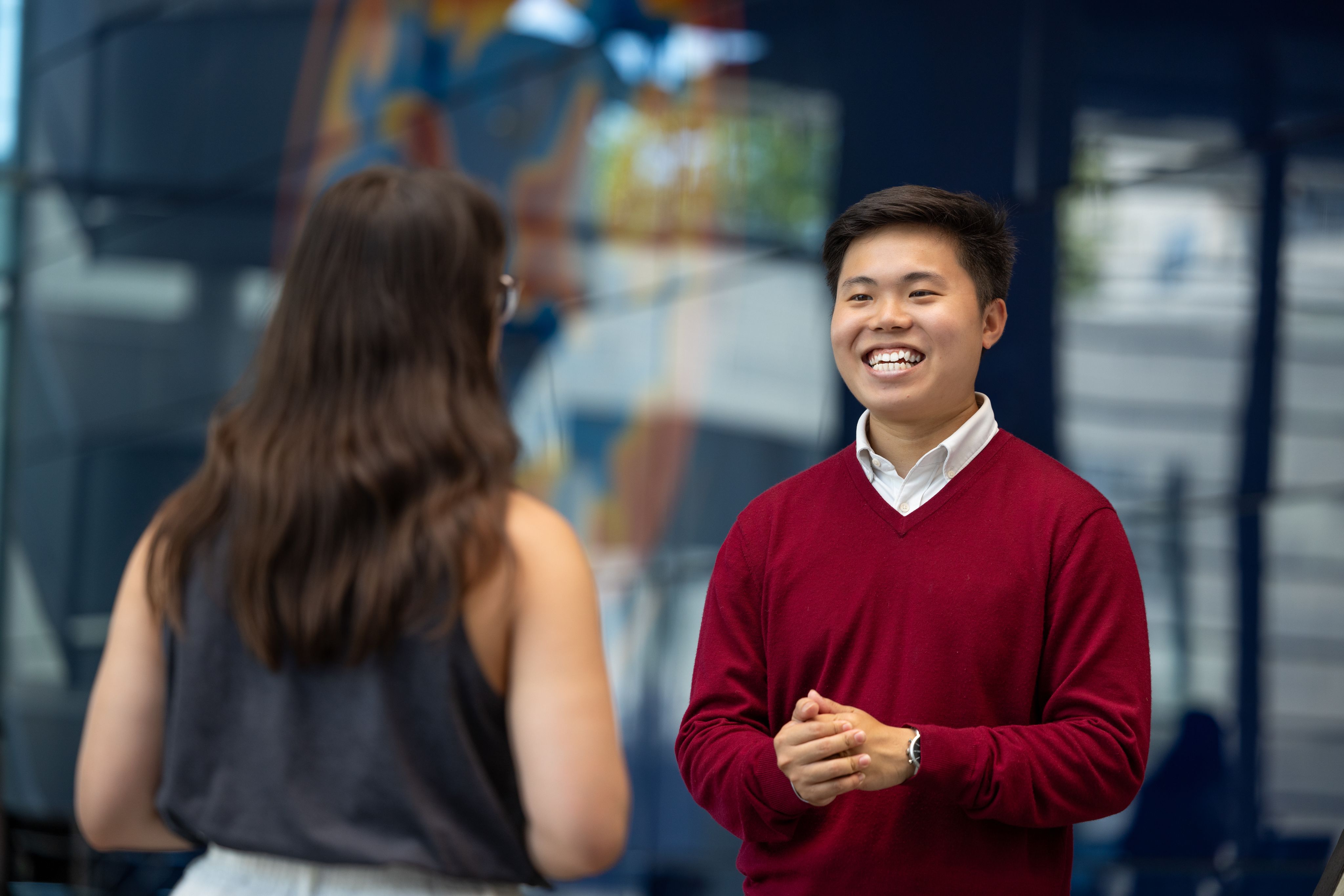 Han Ming smiling and talking to another person 