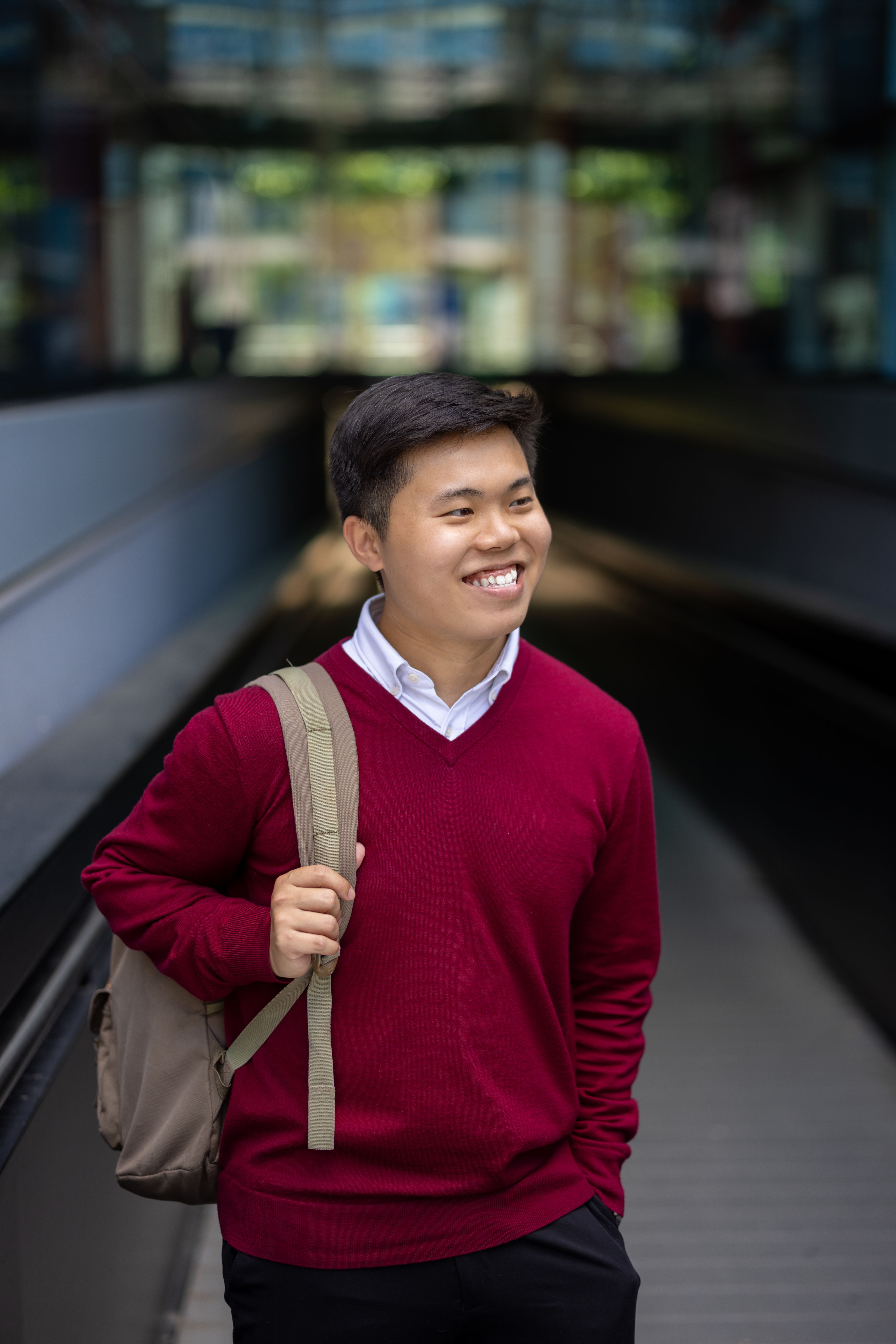 Han Ming holding a backpack on one shoulder on the walkway to Dalby Court on South Kensington Campus