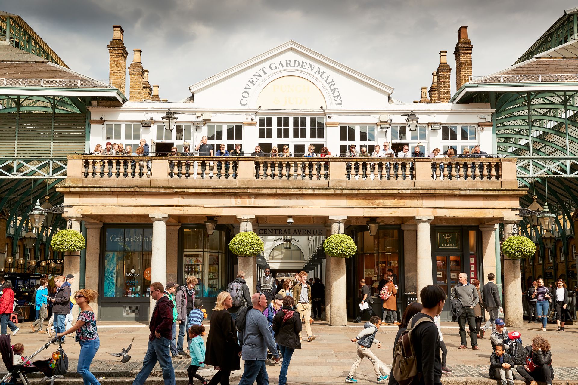 People sitting on a balcony at the entrance to Covent Garden Market in London