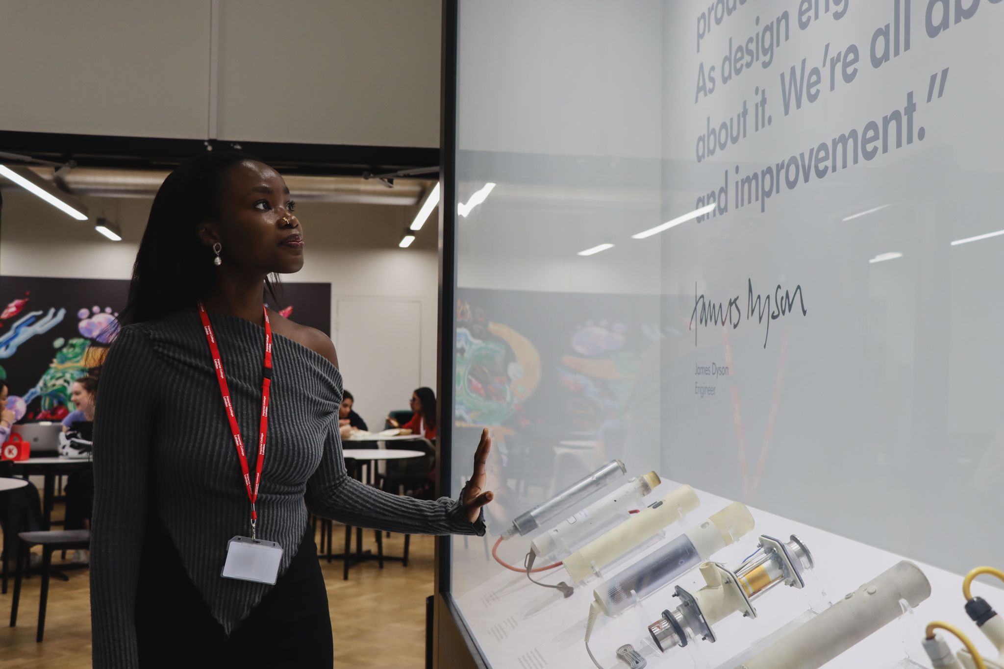 Ifeoluwa smiling and looking up at a printed quote from engineer James Dyson