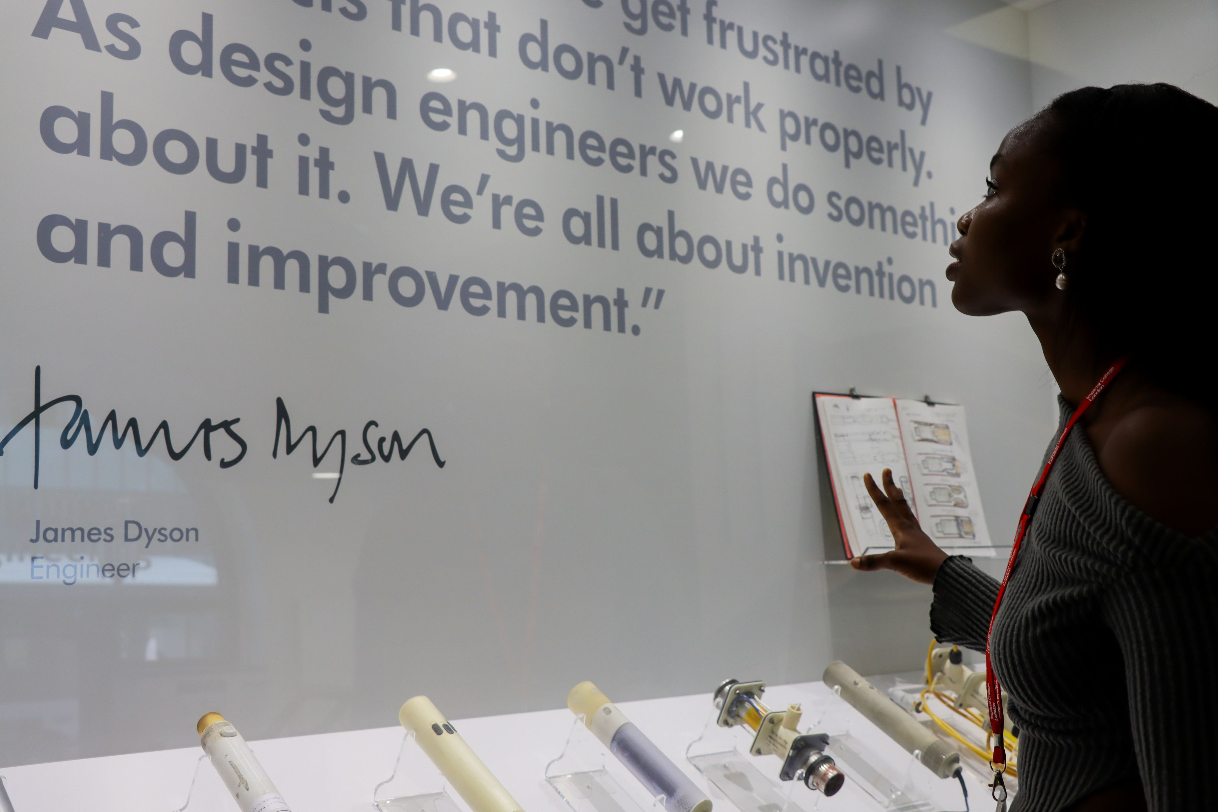 Ifeoluwa looking up at a printed quote from engineer James Dyson