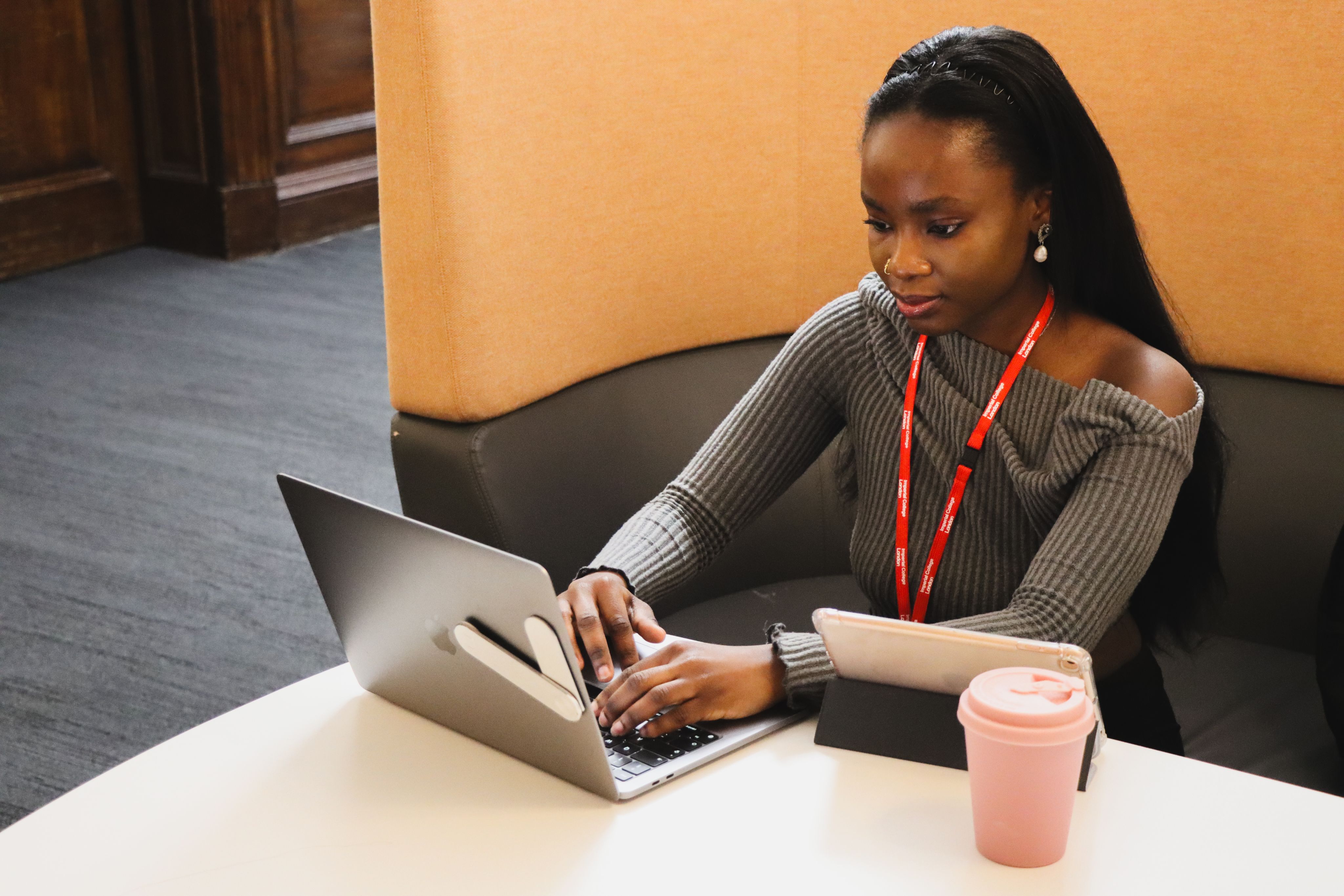 Ifeoluwa sitting down at a desk typing on her laptop