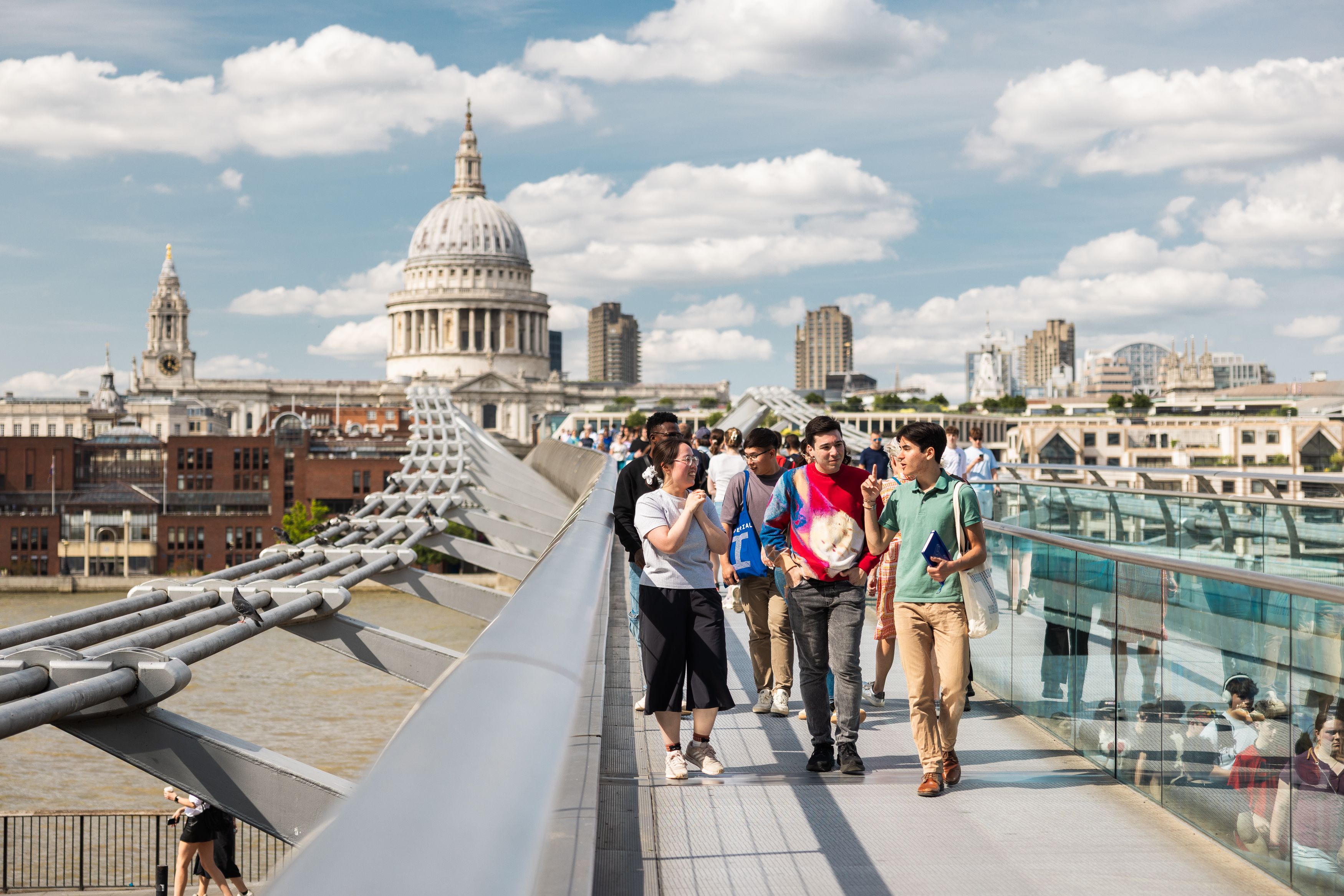 Students walking in London on the Millennium Bridge with St Paul's Cathedral in the background