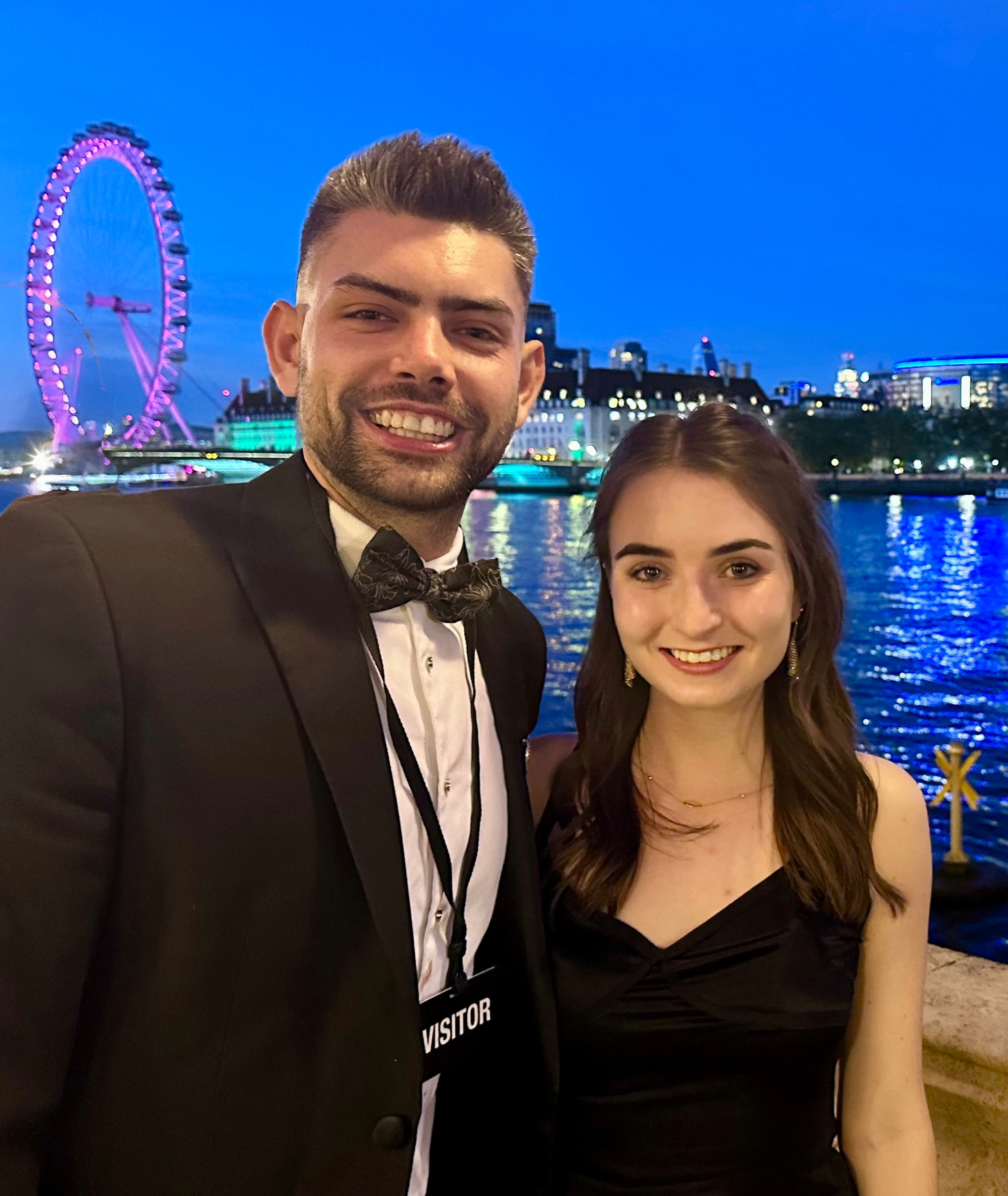 Kyle and a friend in black tie attire with the London Eye in the background