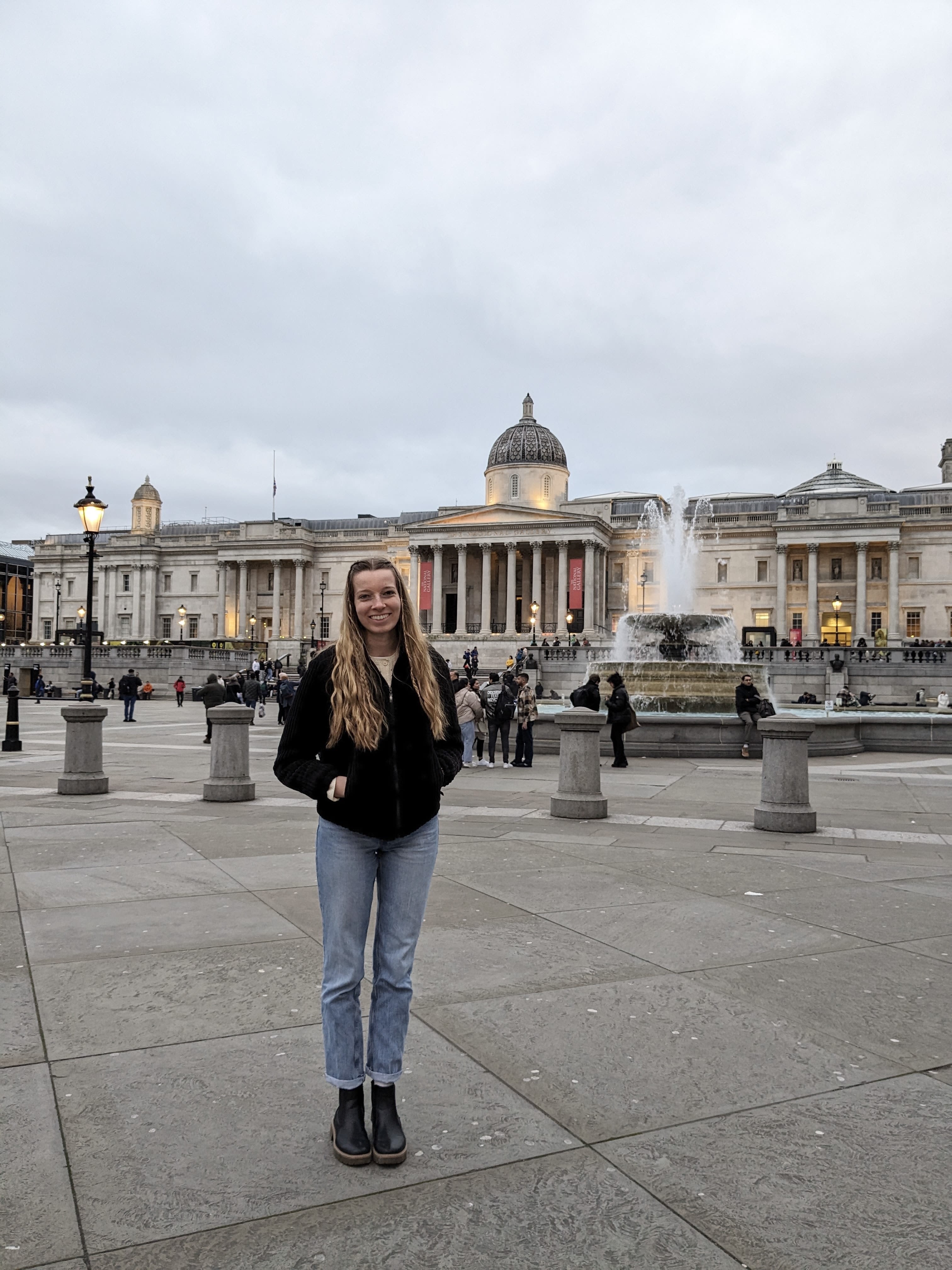 McKenna standing in Trafalgar Square, with the National Gallery behind her.