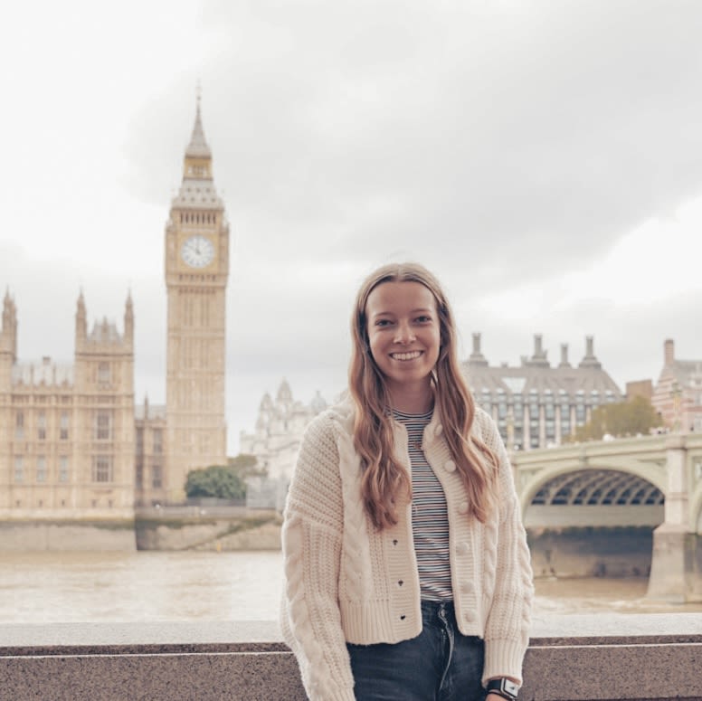 McKenna standing by the River Thames in London with Big Ben in the background