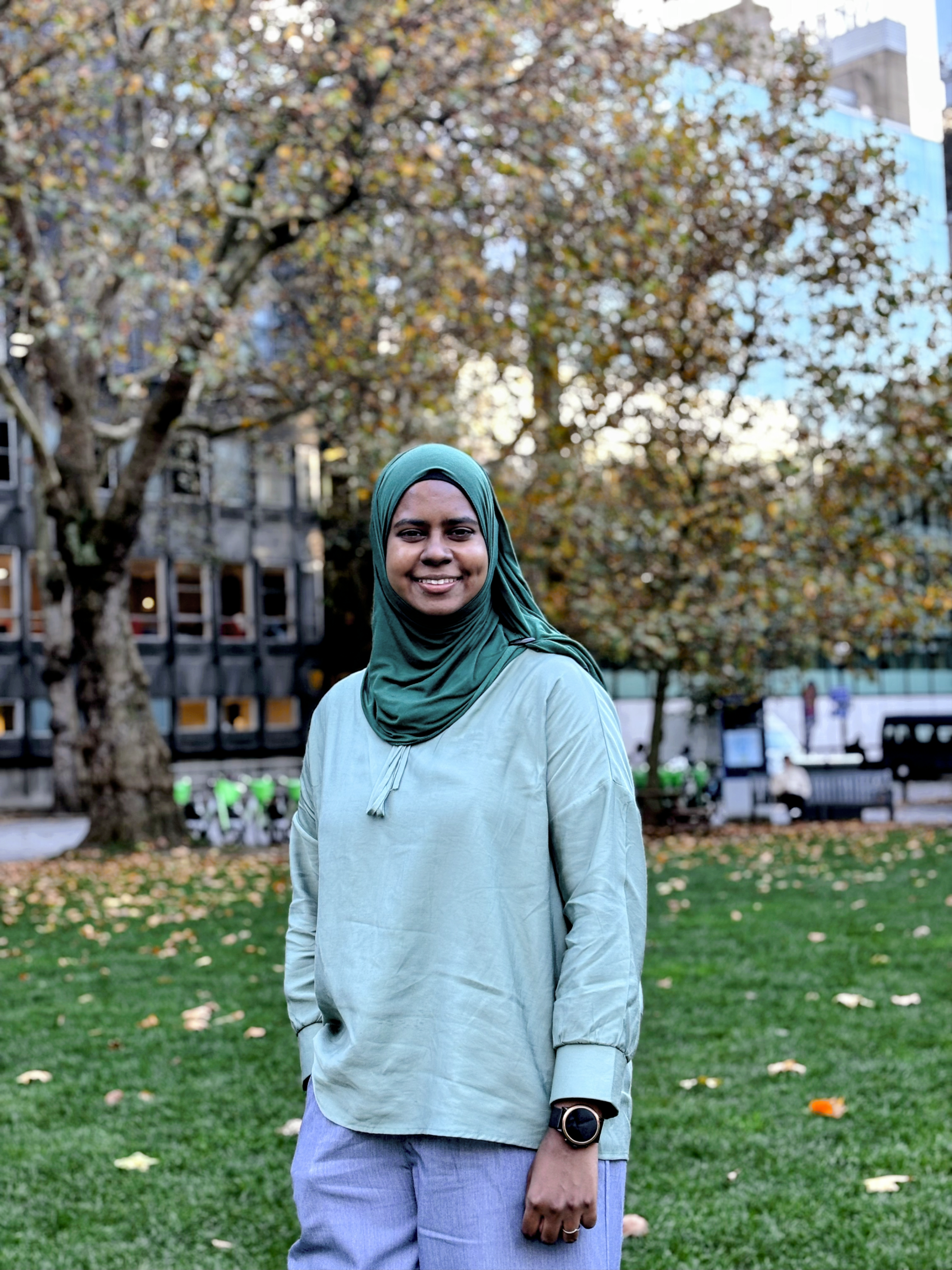 Nafisah standing on Queen's Lawn and smiling at the camera