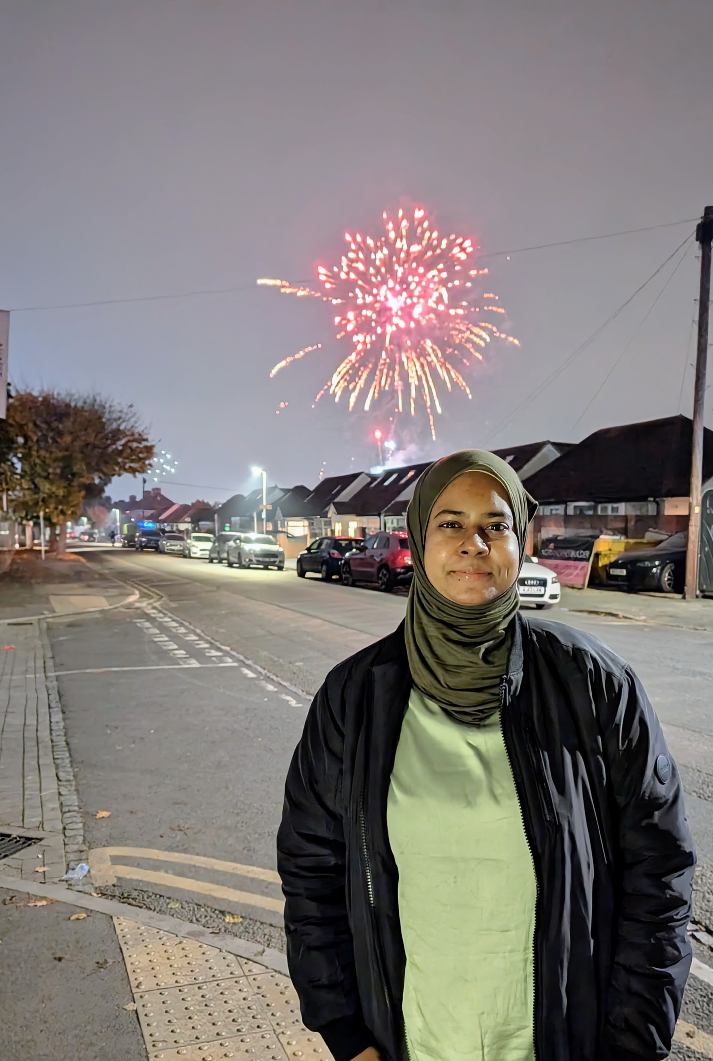 Nafisah posing in front of fireworks in London