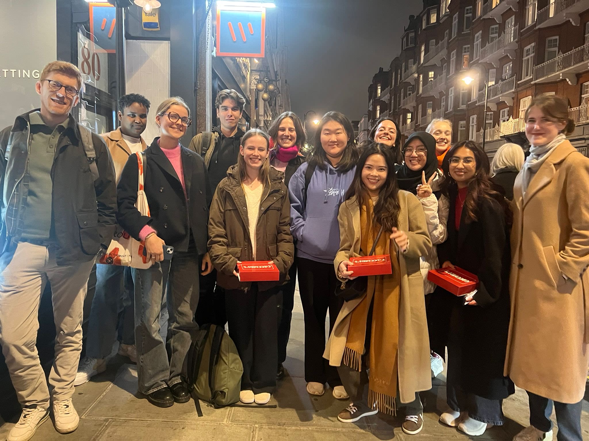 Group photo of Nava and her coursemates outside a restaurant