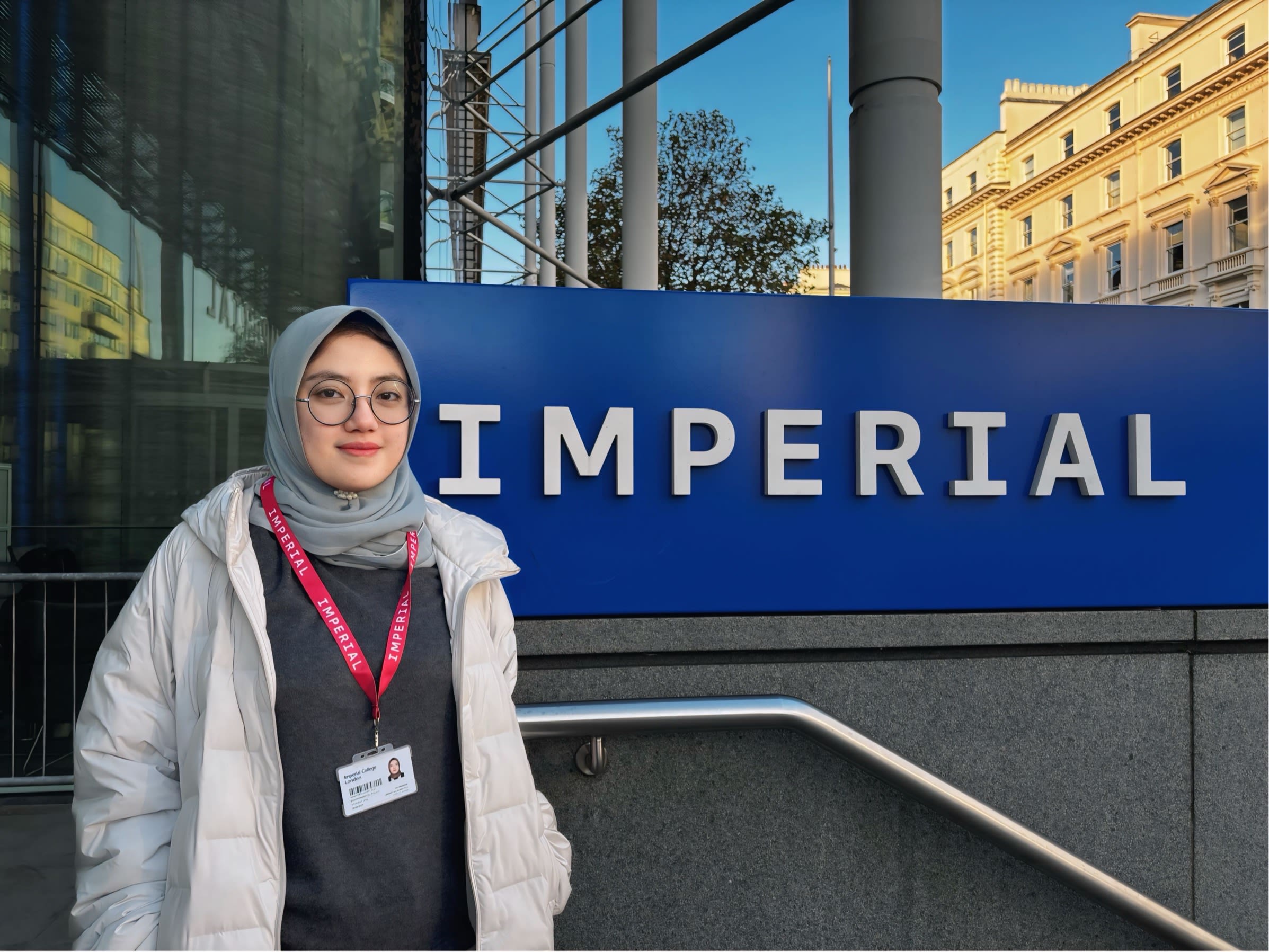 Nava standing outside the main entrance of South Kensington Campus with the Imperial logo