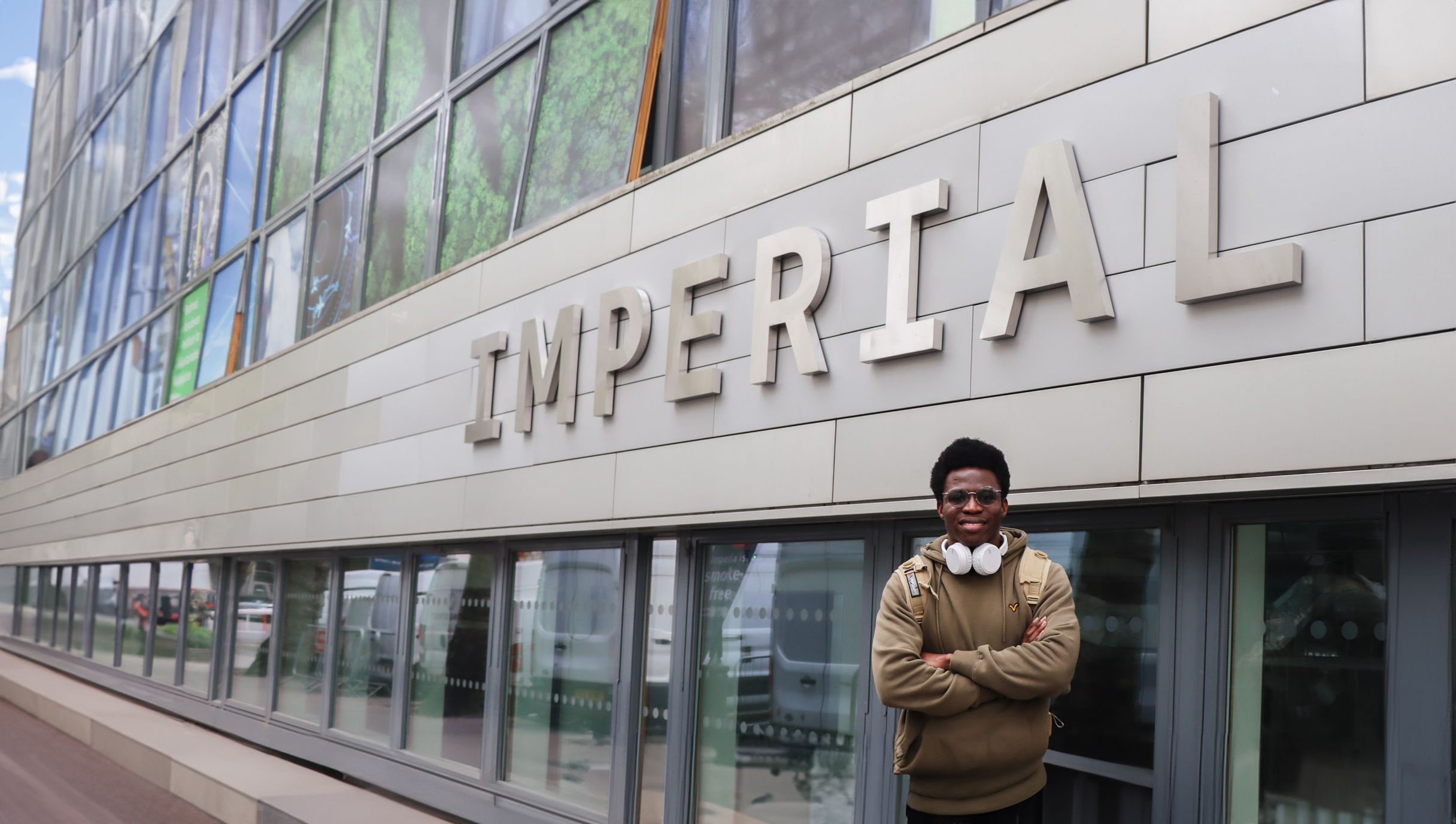 Oluwafemi posing in front of the Imperial logo on South Kensington Campus