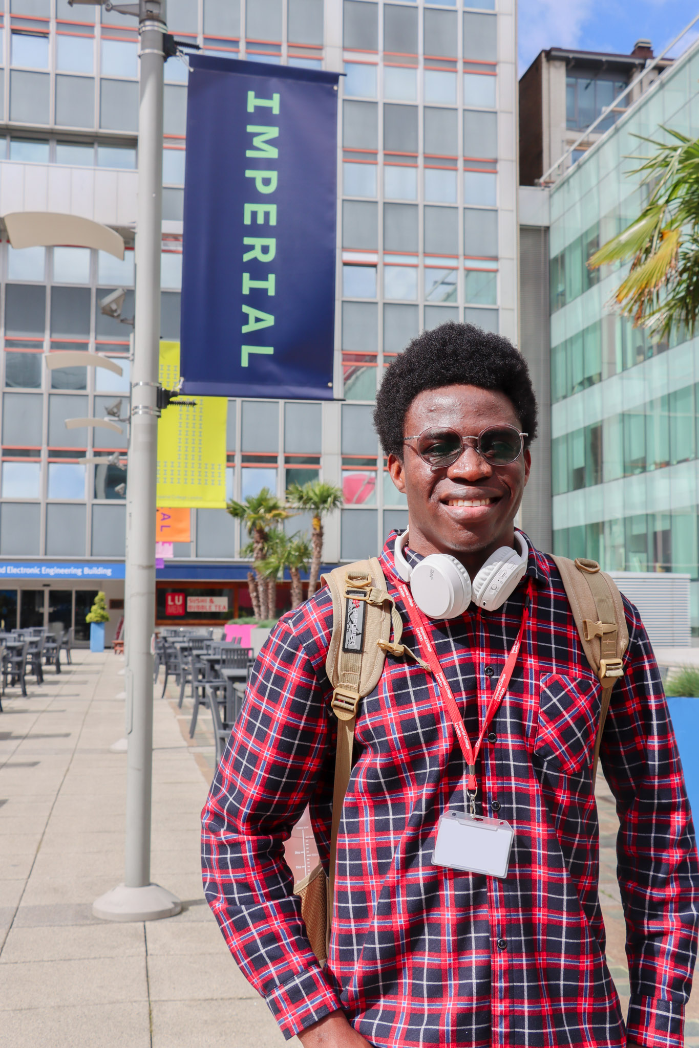 Oluwafemi standing outside in Dalby Court, with an Imperial flag banner behind him