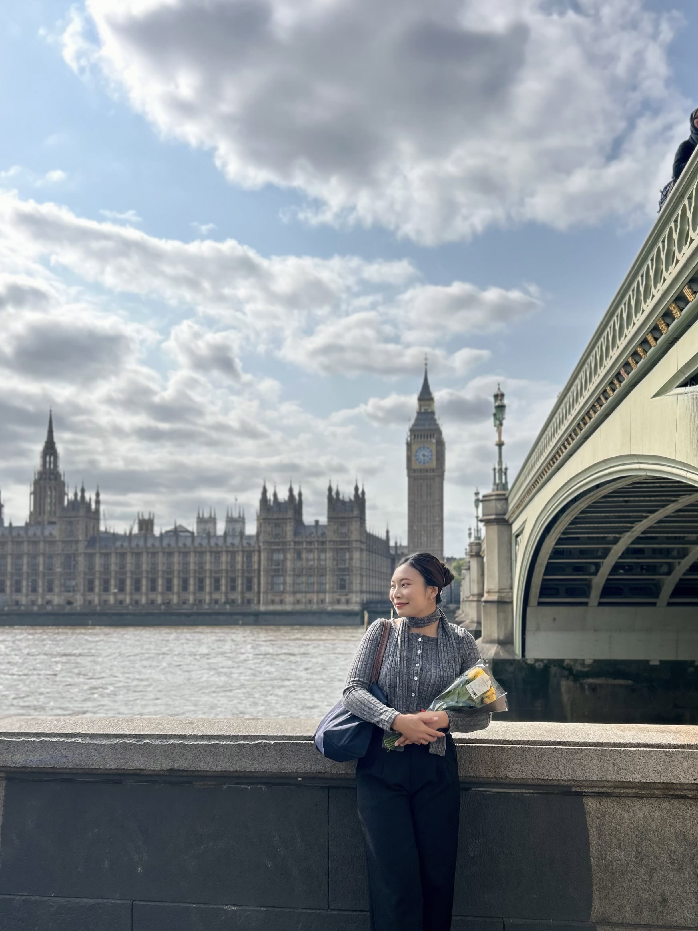 Rose holding a bouquet of flowers with the Houses of Parliament and Big Ben in the background