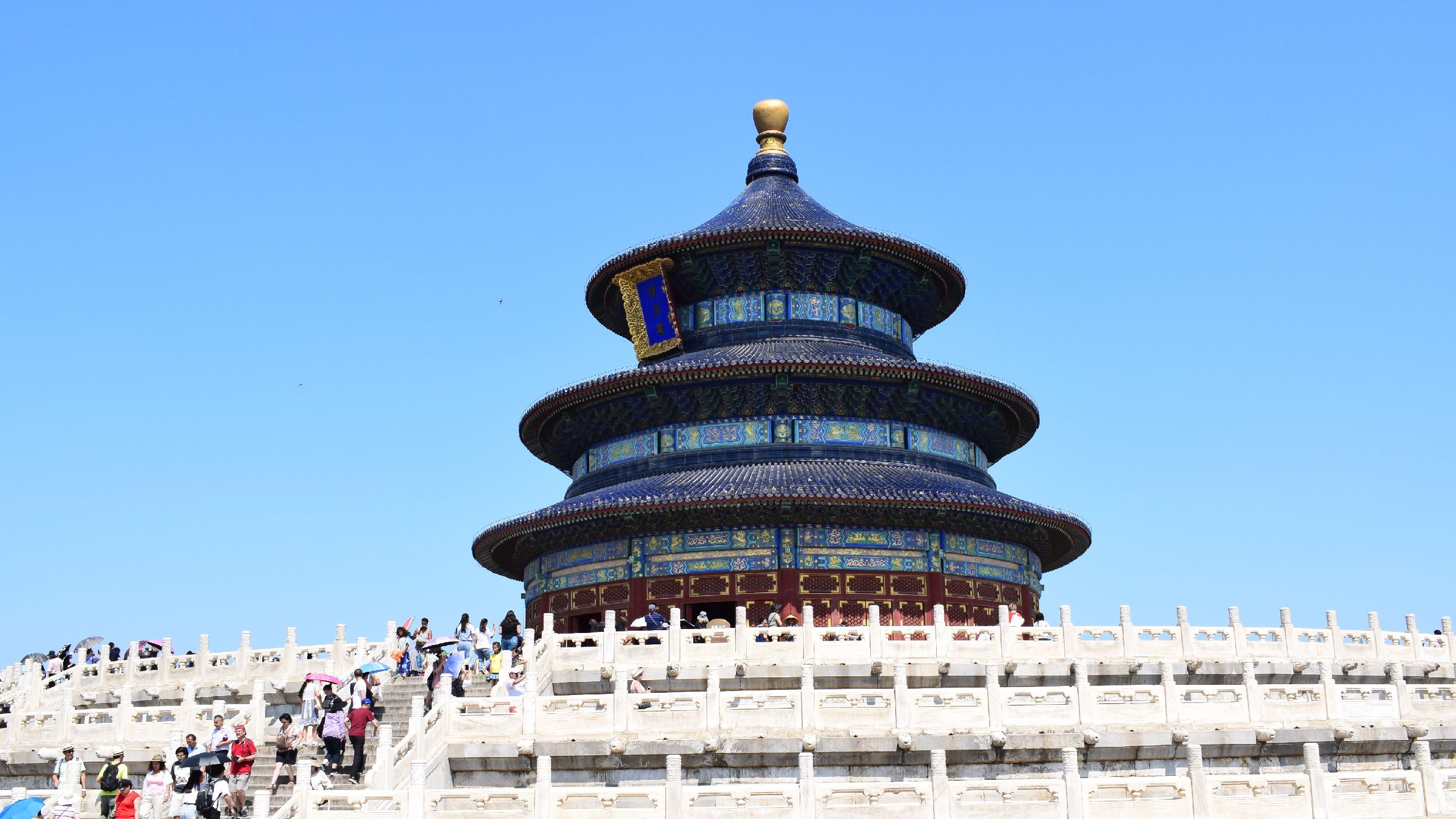A blue temple building set against a sunny sky.