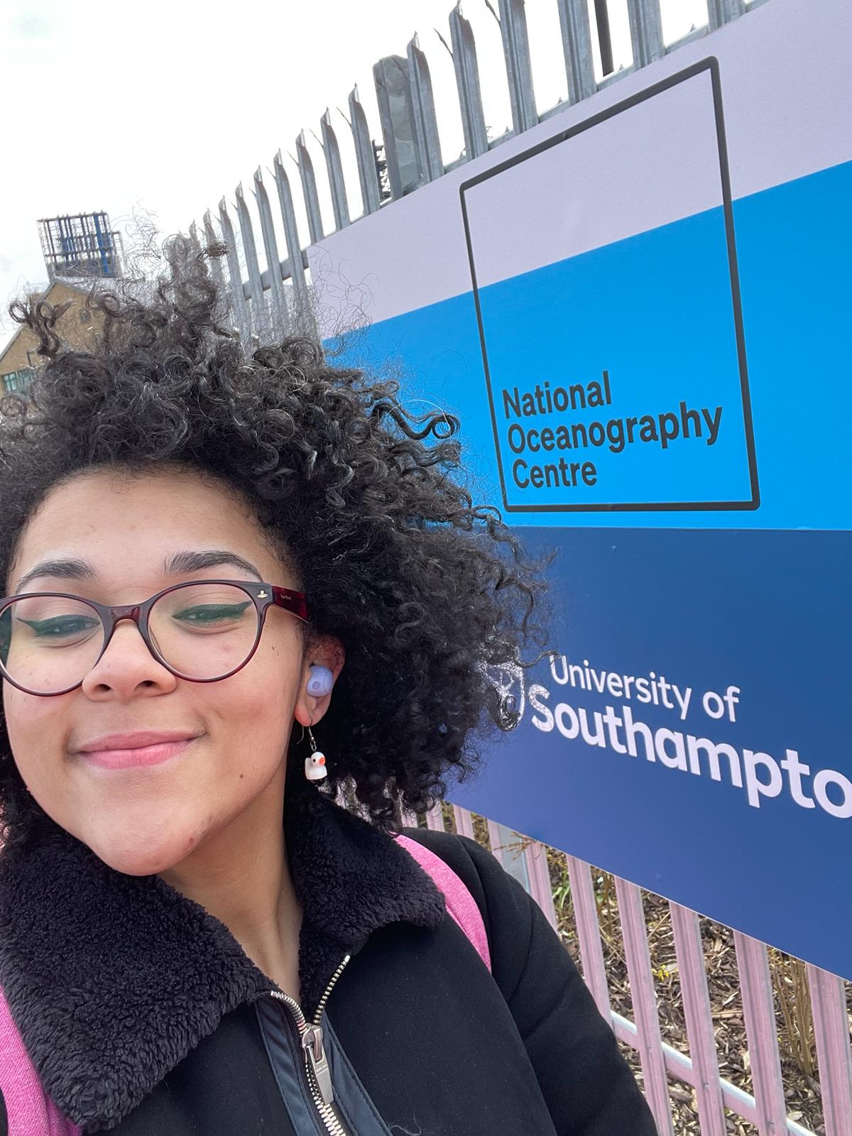 Vanessa standing in front of a sign that says 'National Oceanography Centre' at the University of Southampton