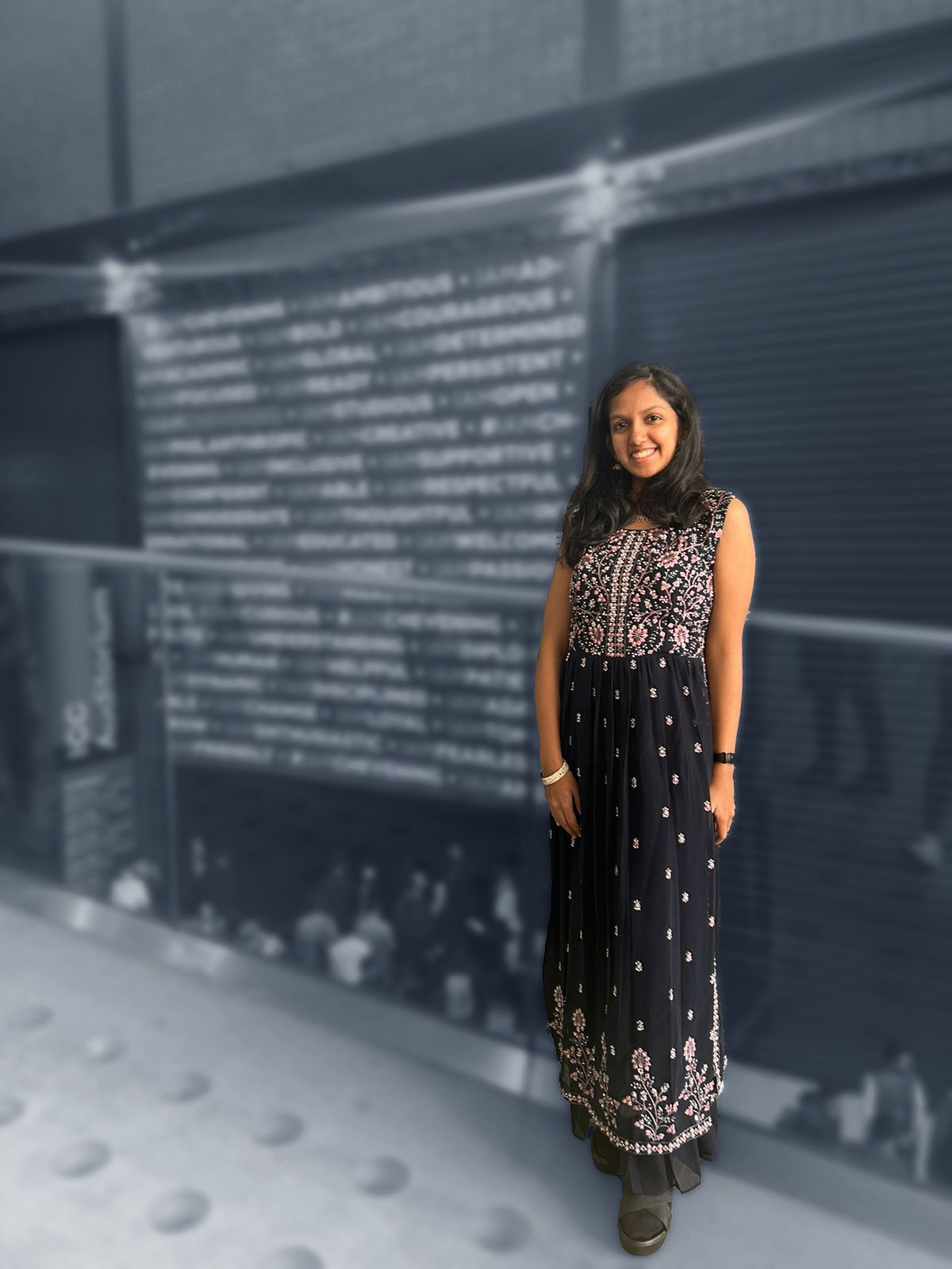 Vanya standing in front of a Chevening Scholars banner at an event