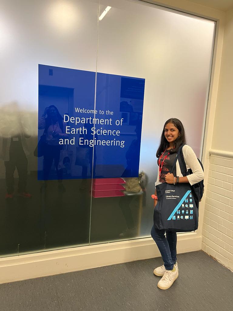 Vanya standing in front of sign saying 'Welcome to the Department of Earth Science and Engineering'