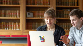 Dr Fredi Otto and Dr Noah Walker-Crawford in discussion in front of a laptop in a courtroom