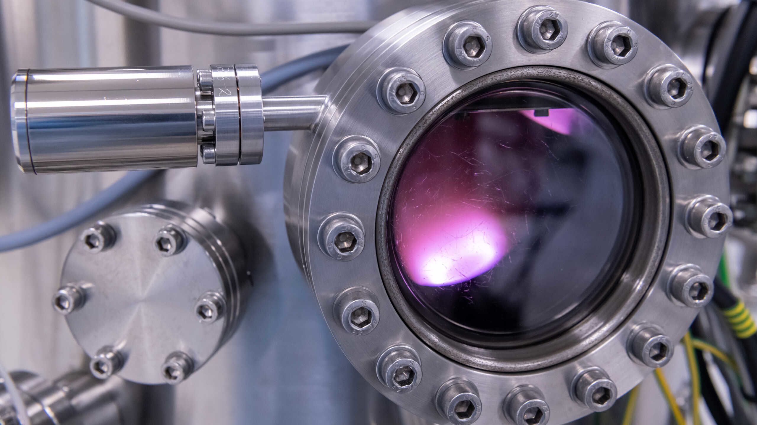 A pink light shows through the window of a scientific instrument.
