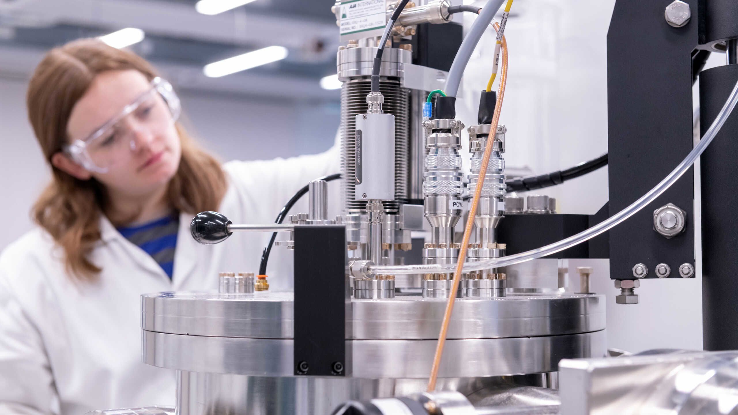 A researcher sits behind a scientific instrument