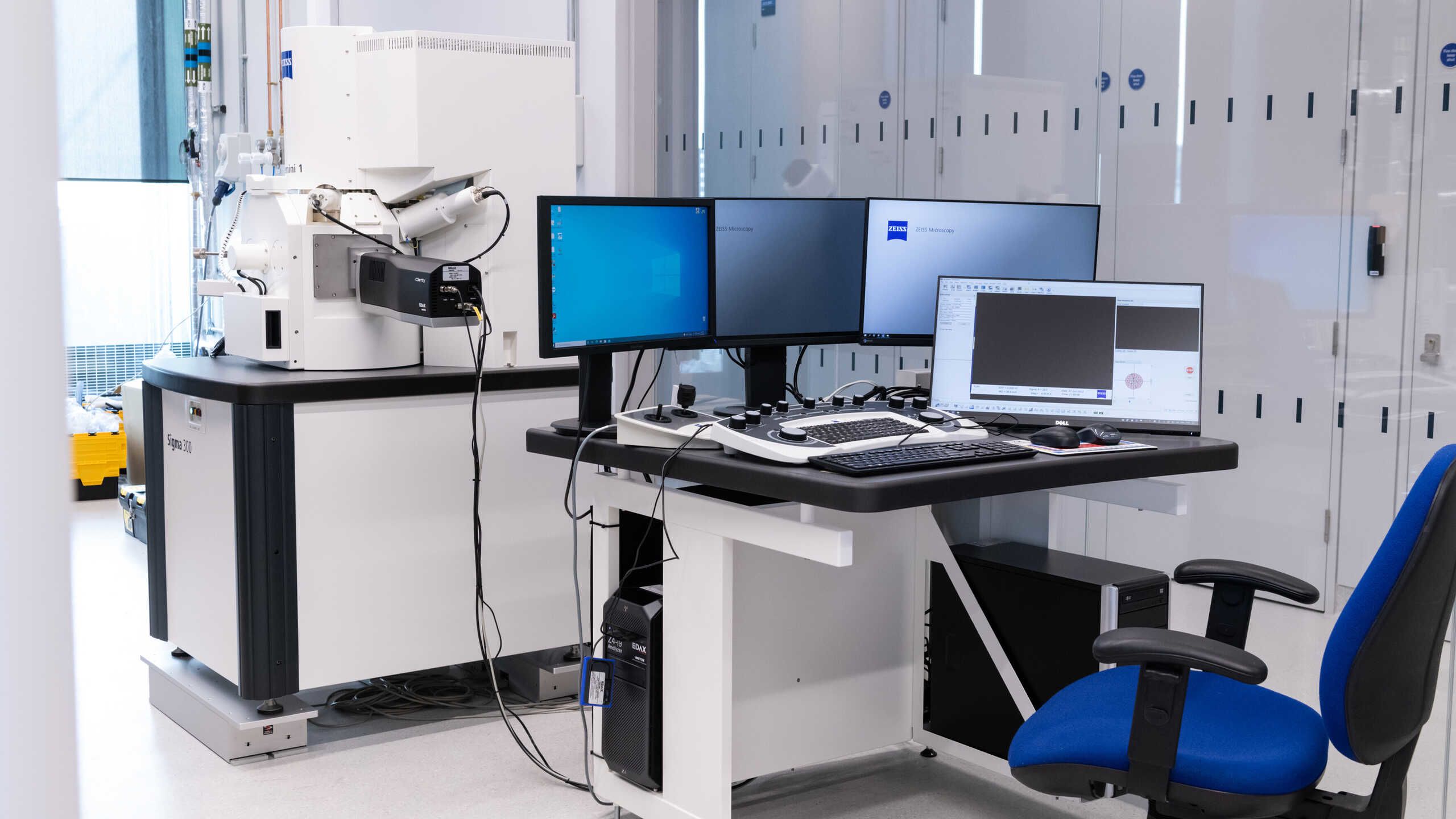 A scanning electron microscope, screens and desk.