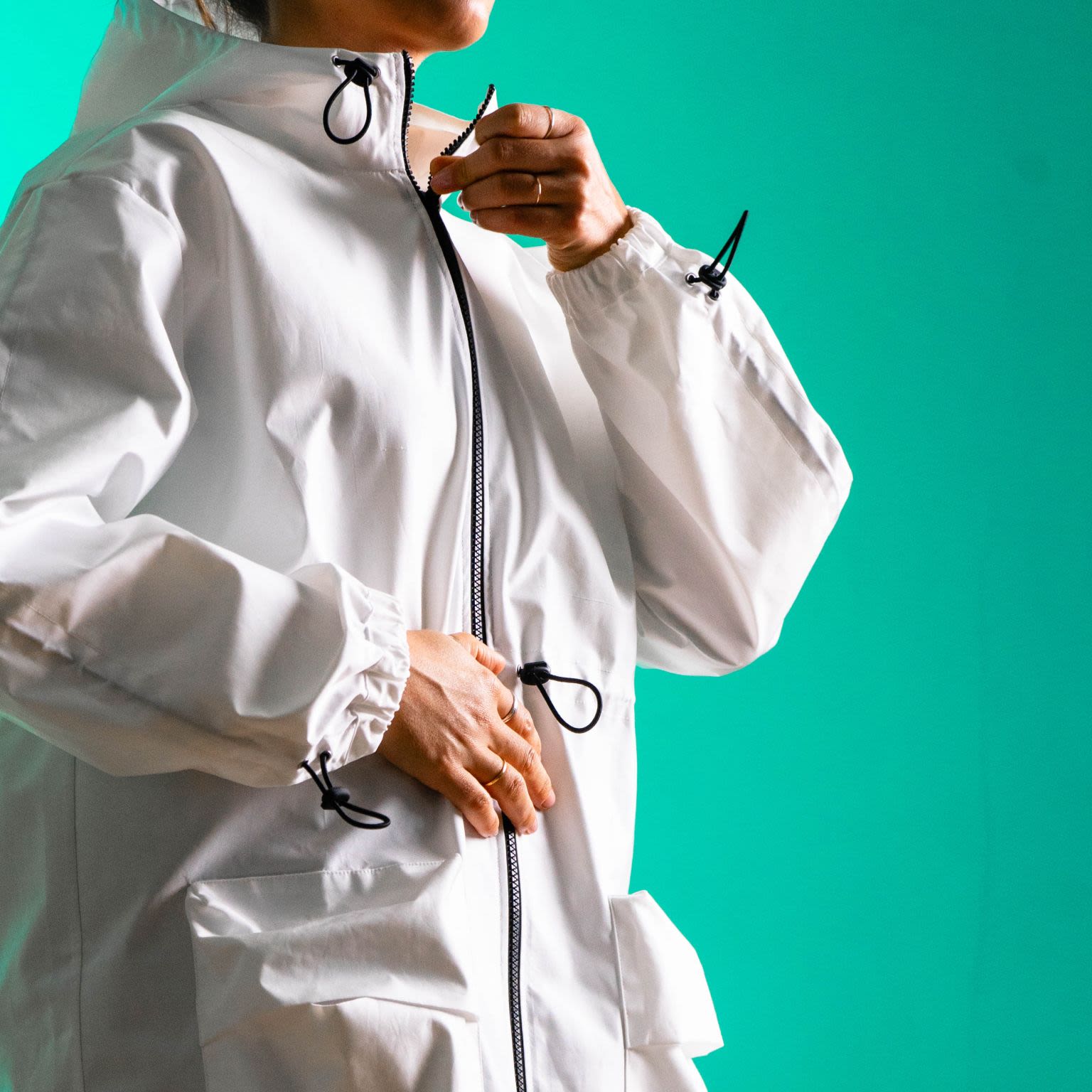A model wears a while waterproof parka.