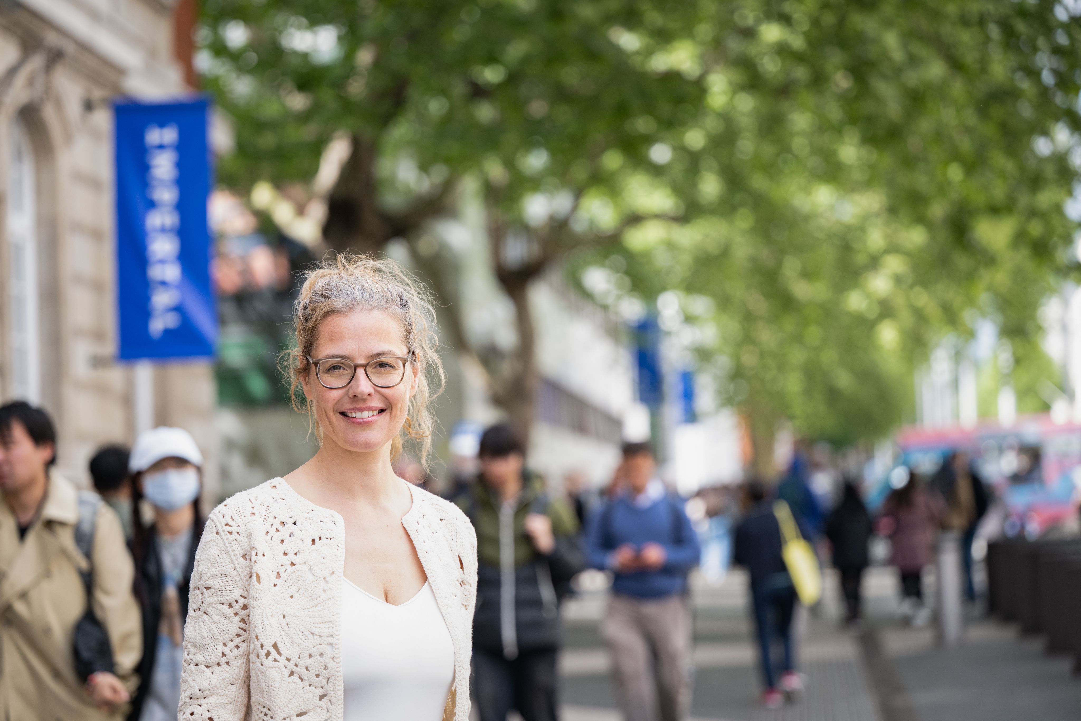 Sabine smiling in front of a blurred background on Exhibition Road.