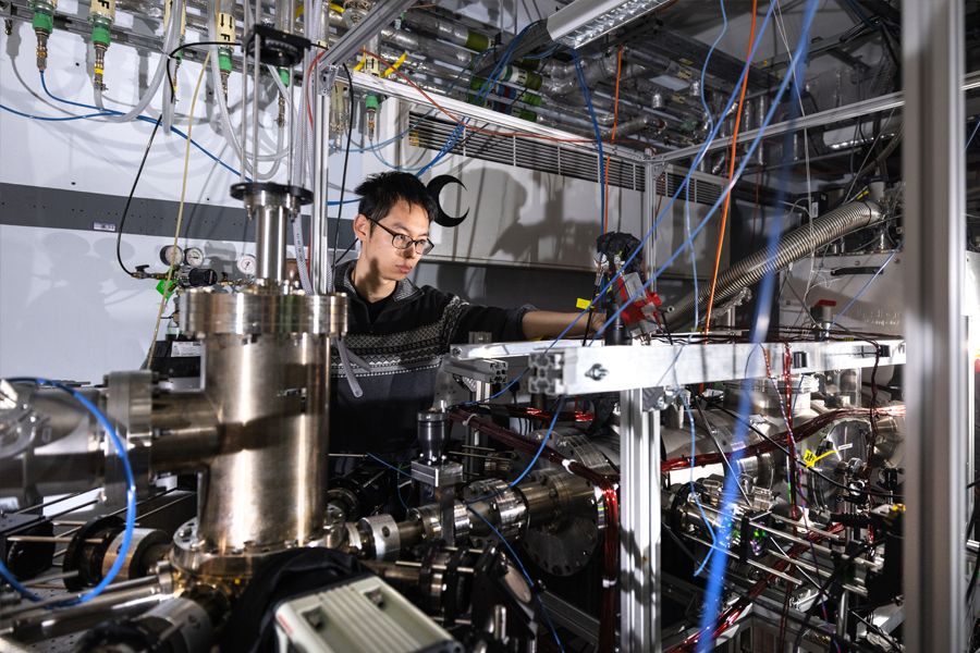 A scientist looks into an experiment featuring a vacuum chamber