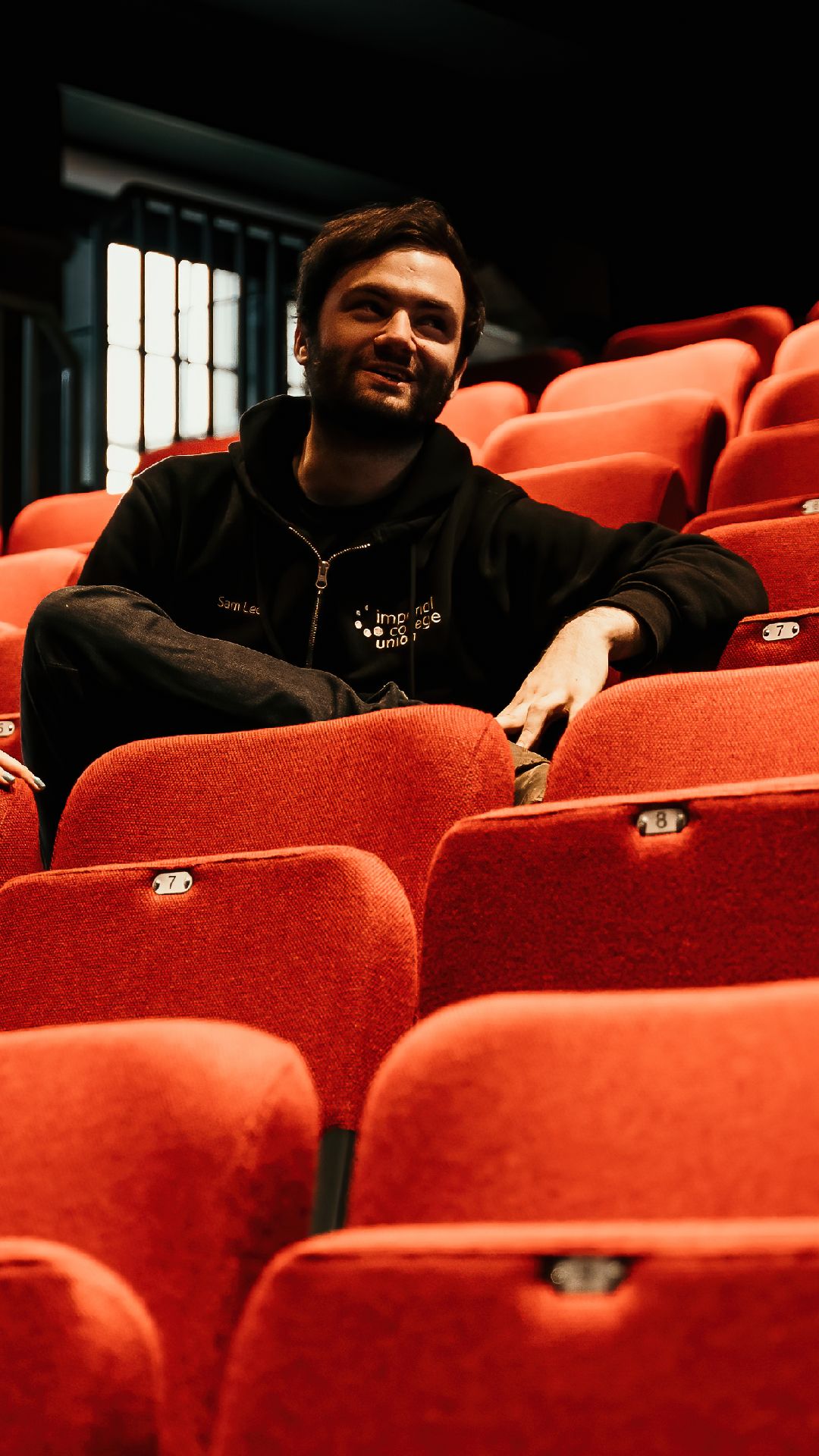 Sam sitting on the seats of the Concert Hall