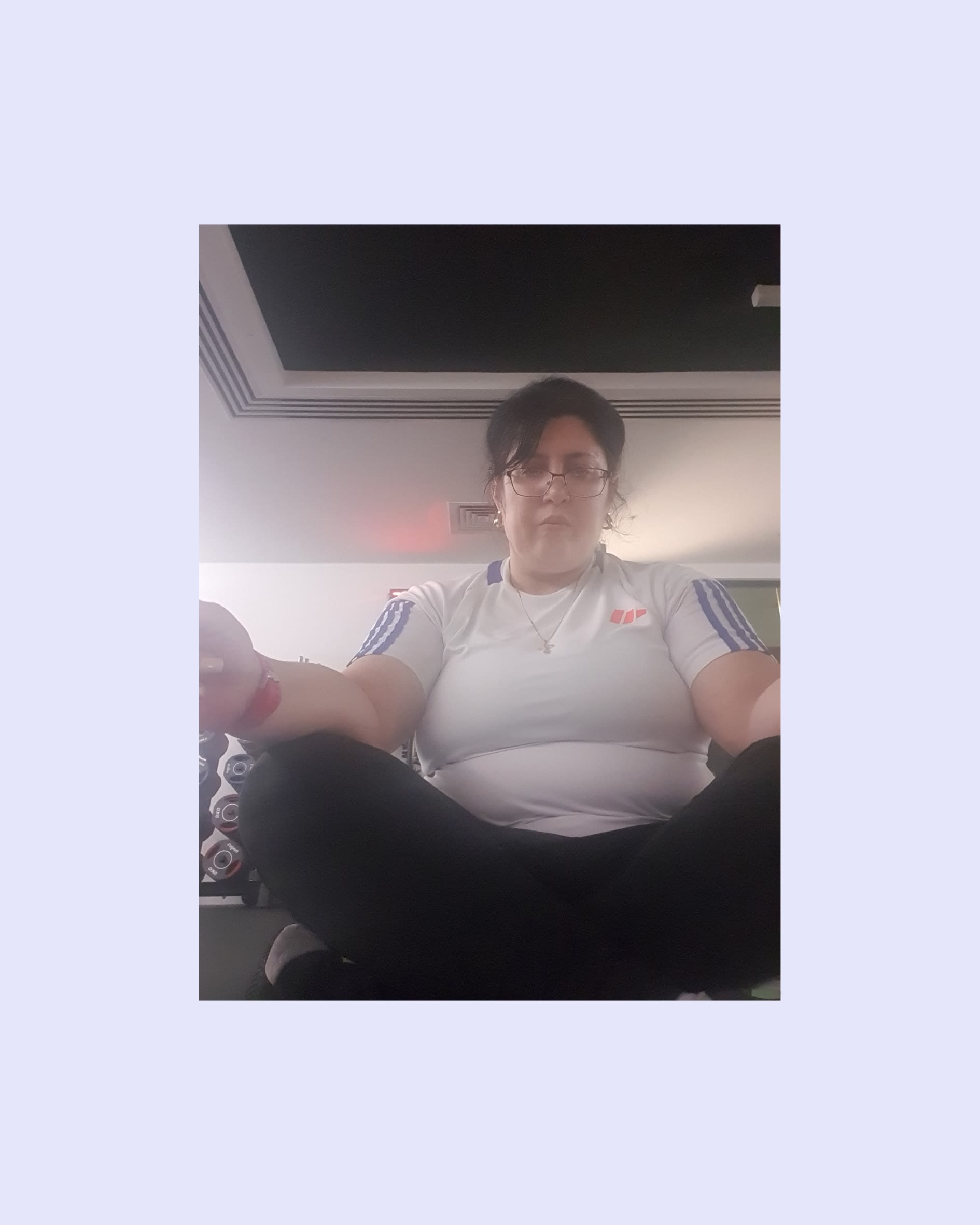 A woman sitting cross-legged with her arms resting on her legs.