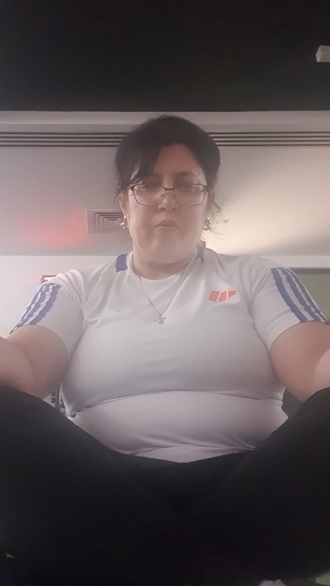 A woman sitting cross-legged with her arms resting on her legs.