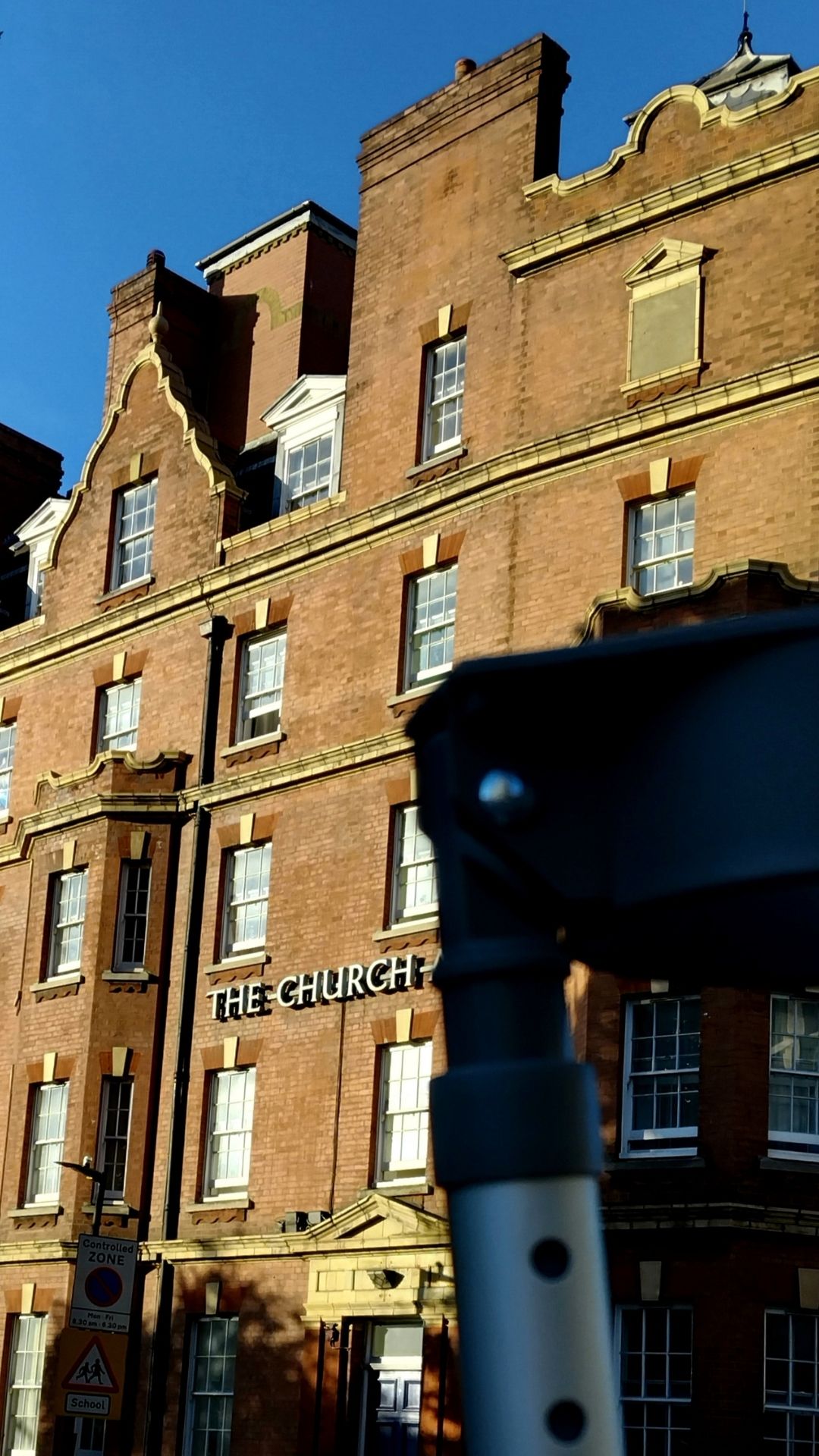 A crutch in the foreground and a building with the words The Church on it in the background.