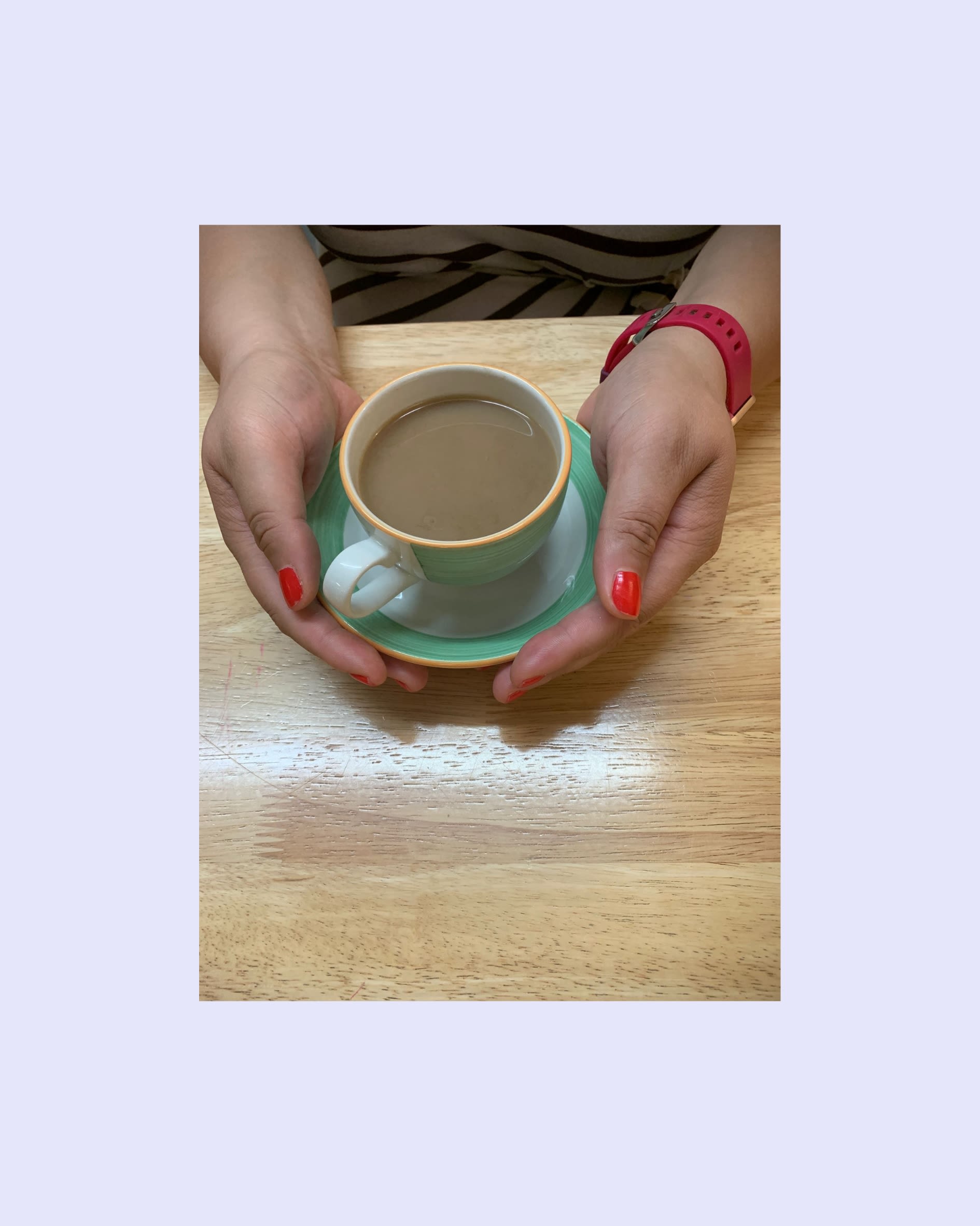 Two hands holding a green mug filled with tea.