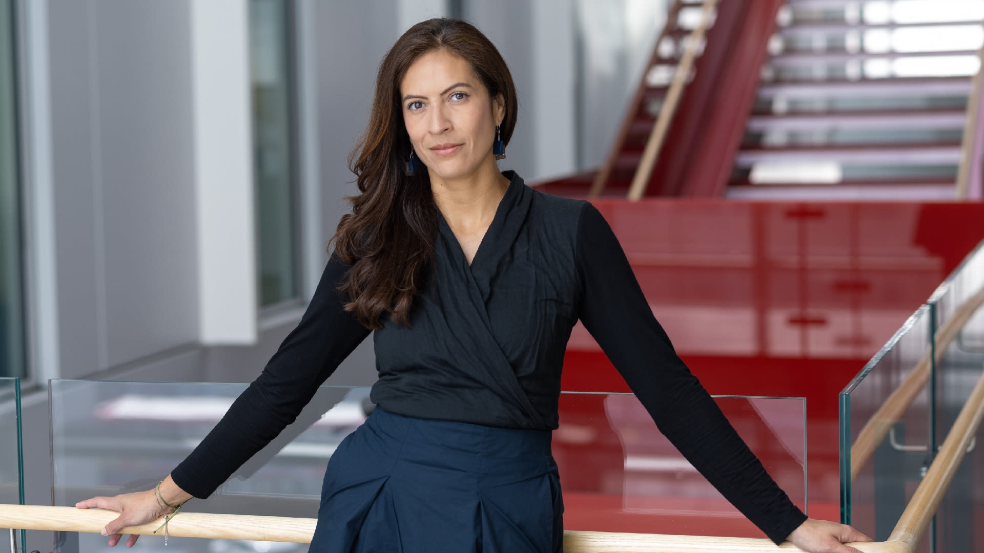 Paula leaning against a handrail with stairs in the background