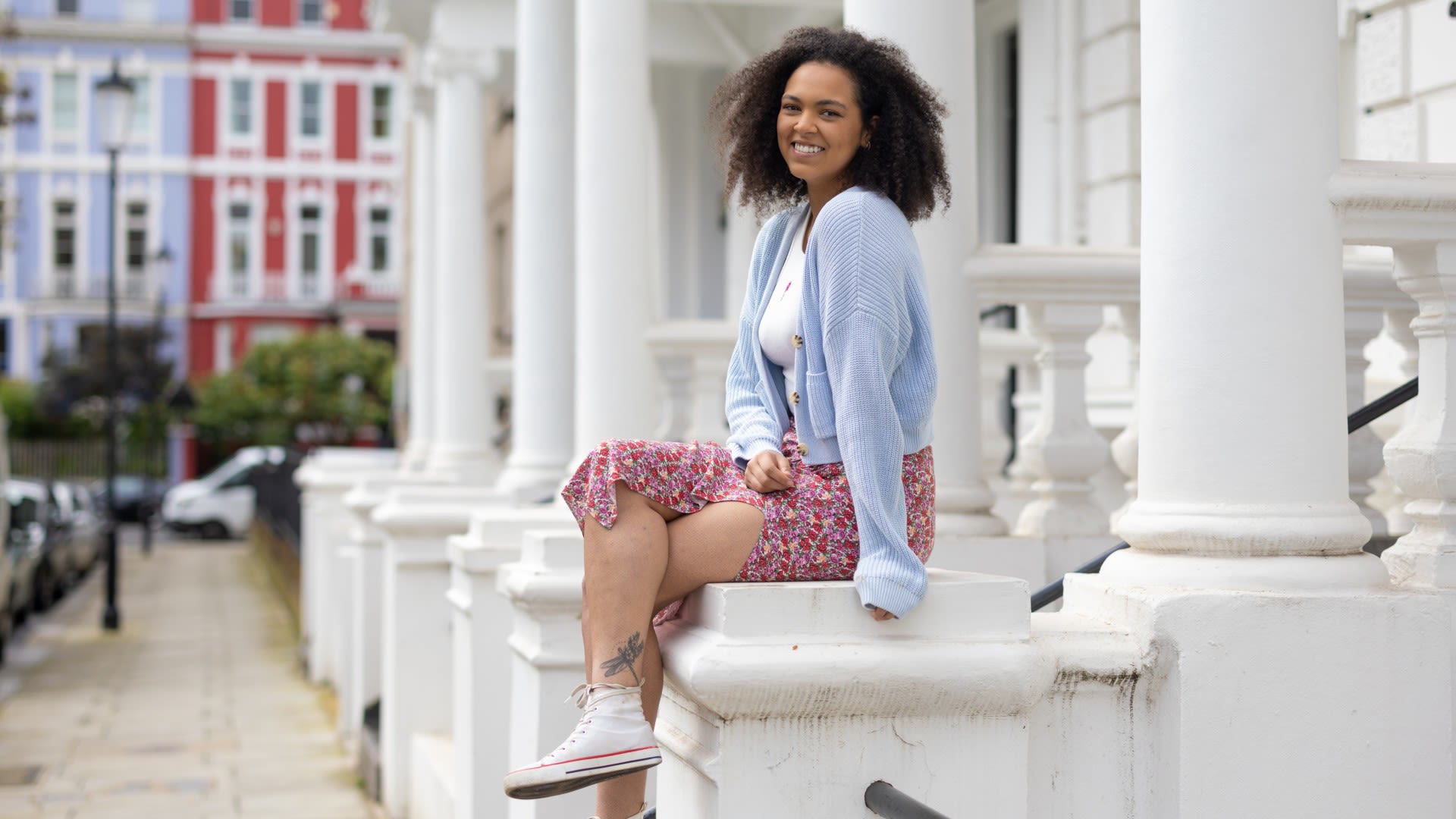 Hollie sitting on a wall smiling 