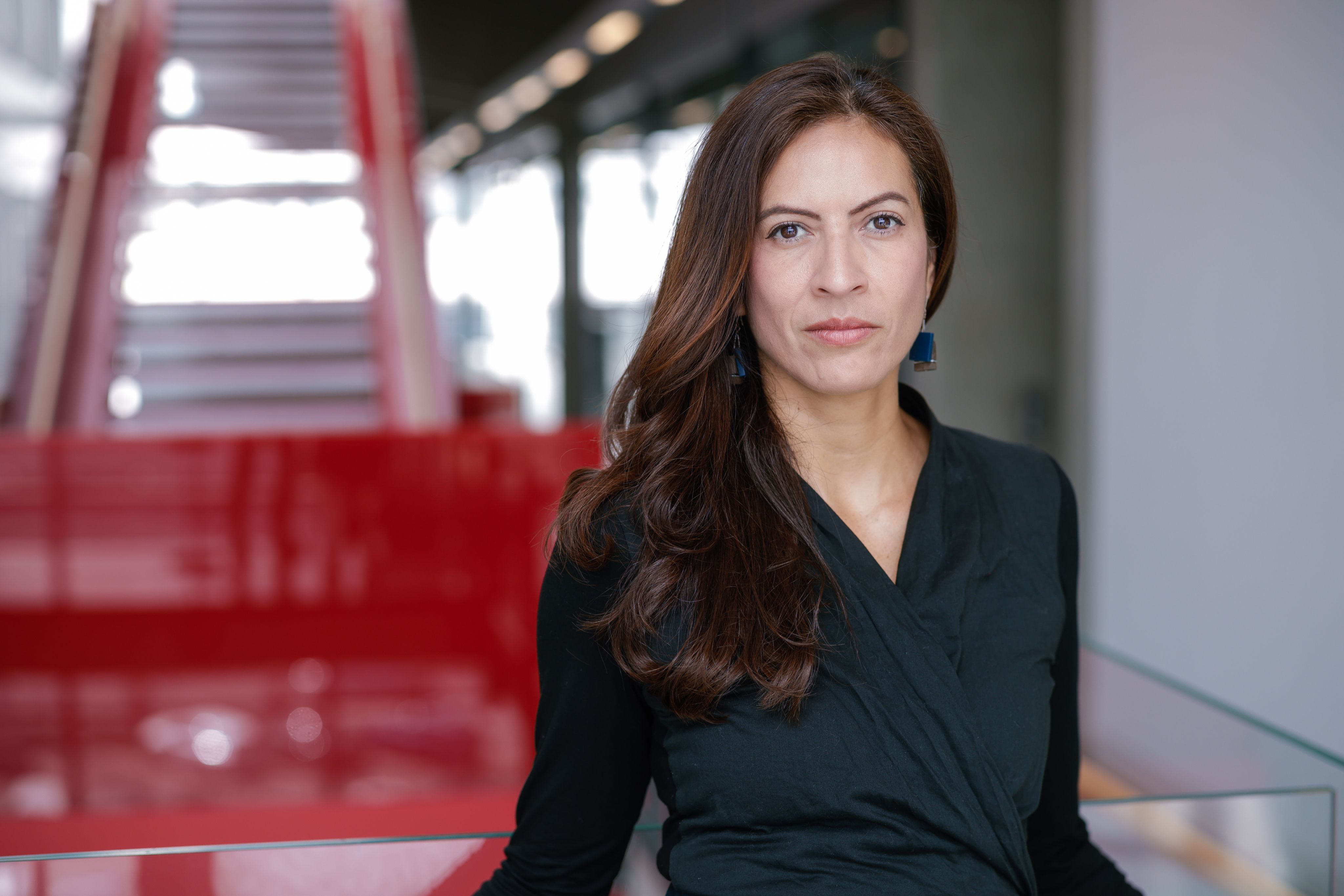 Paula looking at the camera with a red background