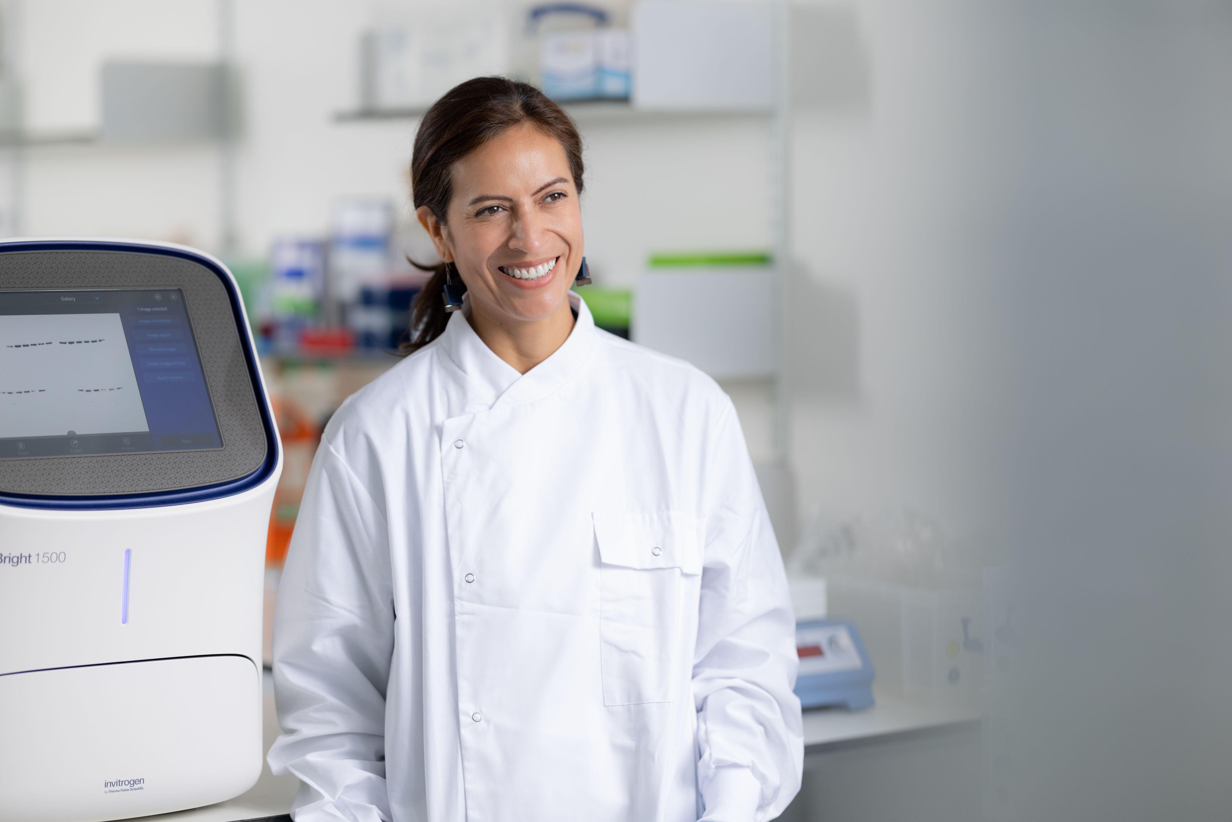 Paula wearing a lab coat and standing in a lab