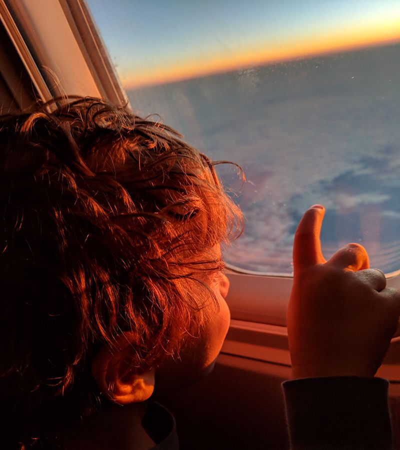 A small child looking out of a plane window